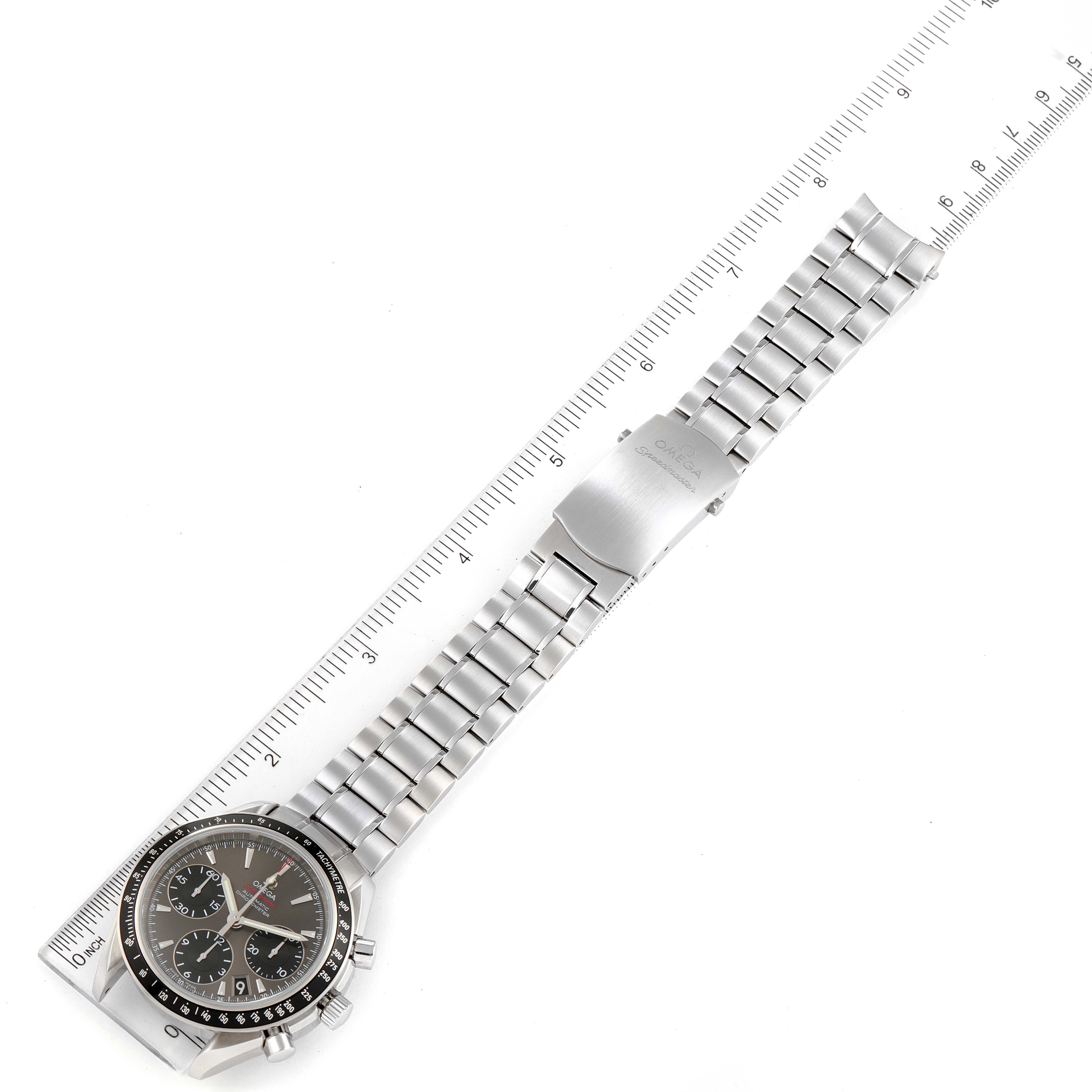 The Omega Speedmaster 323.30.40.40.06.001 Men's Stainless Steel Grey Dial 323.30.40.40.06.001 Men's Stainless Steel Grey Dial watch is shown flat with its face to the left and bracelet fully extended, placed alongside a ruler for measurement.