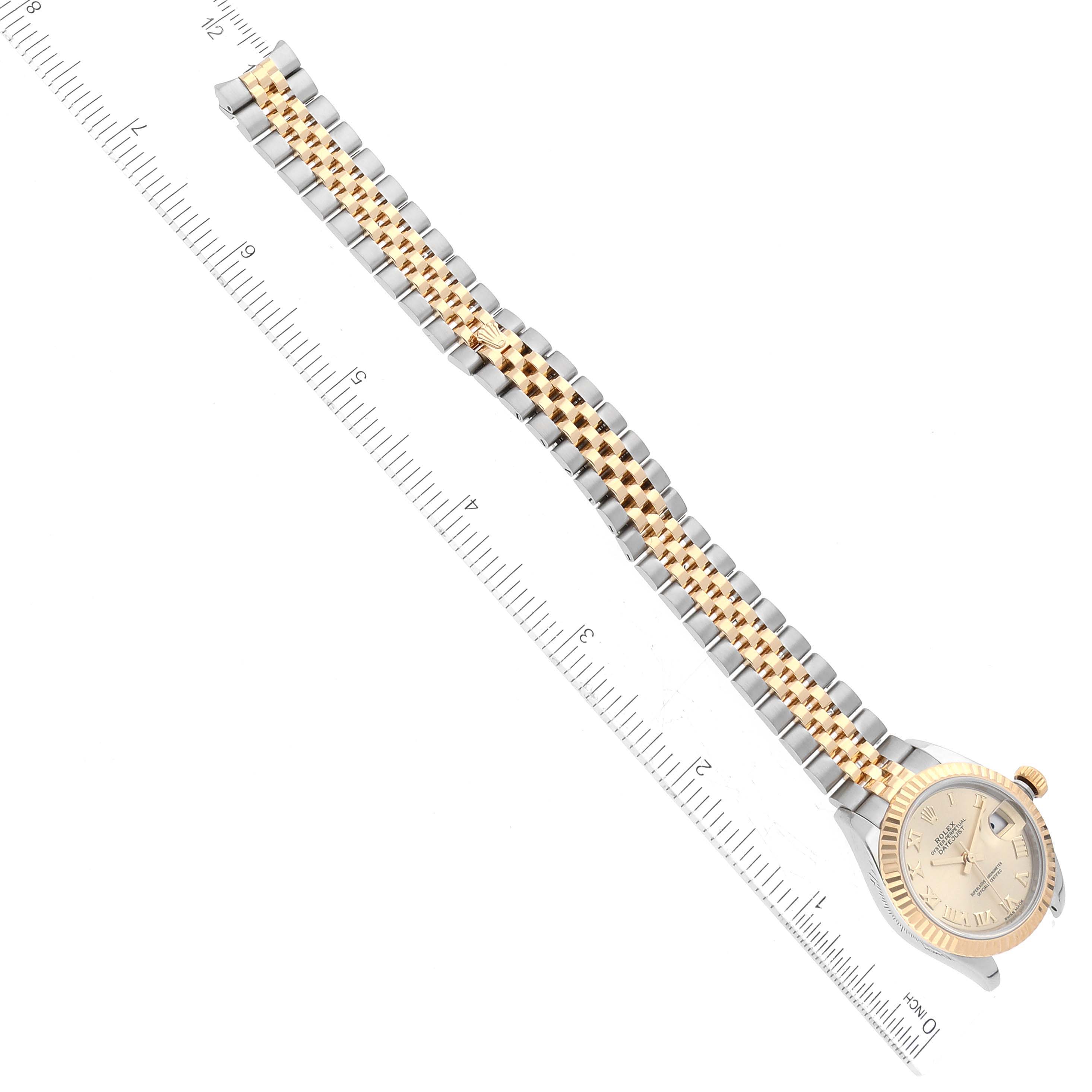 This image shows the Rolex Datejust 279173 Women's Steel and Gold (two tone) Champagne Dial 279173 Women's Steel and Gold (two tone) Champagne Dial watch laid flat with its bracelet extended along a ruler for size comparison.