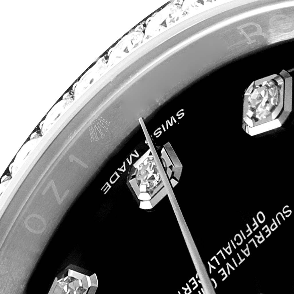This close-up image of a Rolex Datejust 116244 Men's Stainless Steel Black Dial 116244 Men's Stainless Steel Black Dial watch shows part of the dial, bezel with diamonds, and the minute hand.