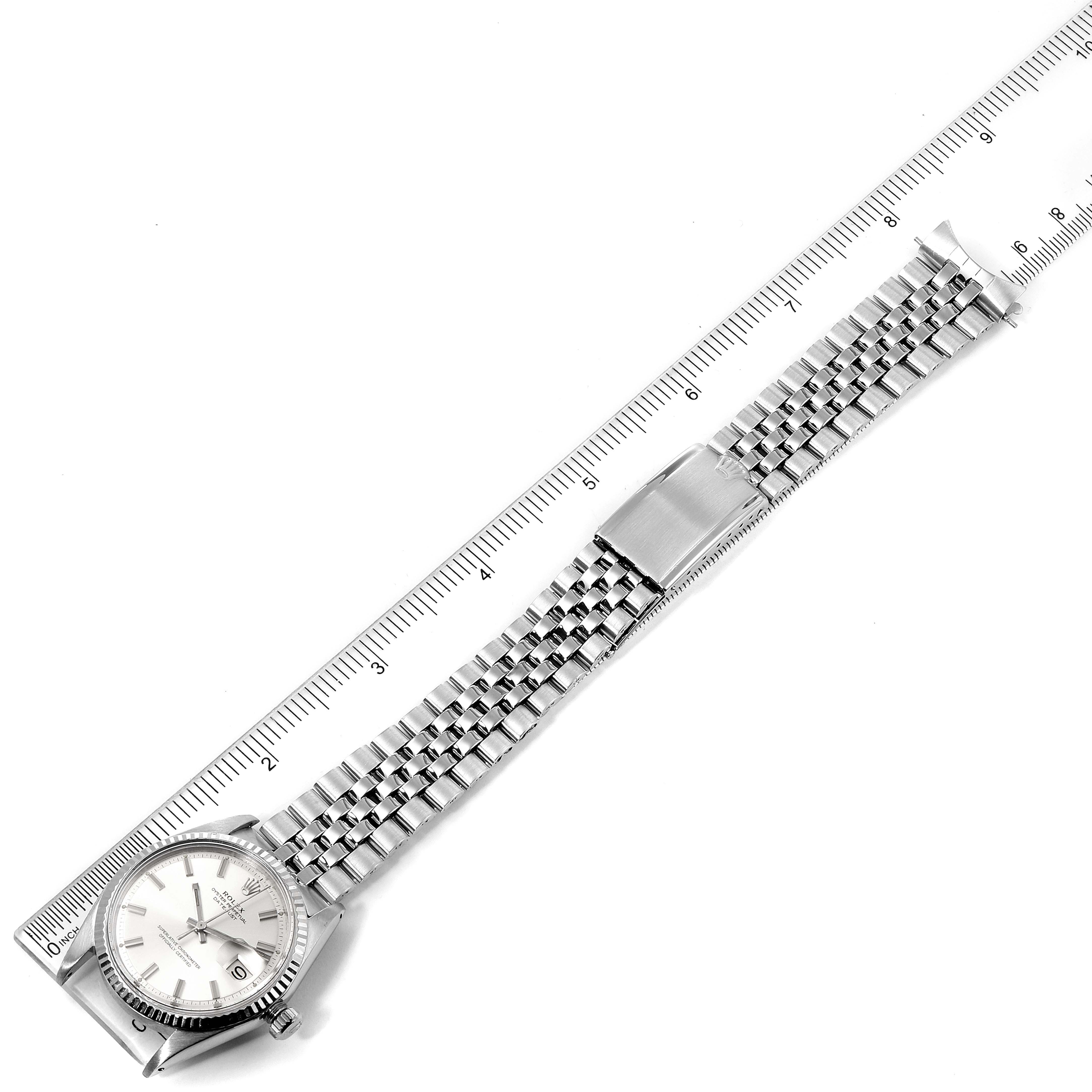 The image shows a Rolex Vintage Collection 1601 Men's Stainless Steel Silver Dial 1601 Men's Stainless Steel Silver Dial watch laid flat with its silver bracelet extended, and a ruler for scale.
