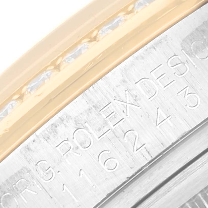 This close-up image shows part of the bezel and engraved inner ring of a Rolex Datejust 116243 Men's Steel and Gold (two tone) Silver Dial 116243 Men's Steel and Gold (two tone) Silver Dial watch.