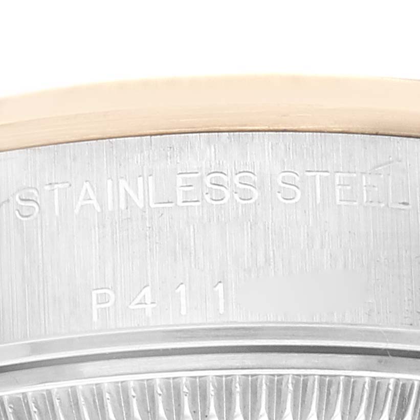 The image shows a close-up of part of the stainless steel bezel on a Rolex Datejust 79163 Women's Steel and Gold (two tone) Champagne Dial 79163 Women's Steel and Gold (two tone) Champagne Dial watch, revealing engraved text.