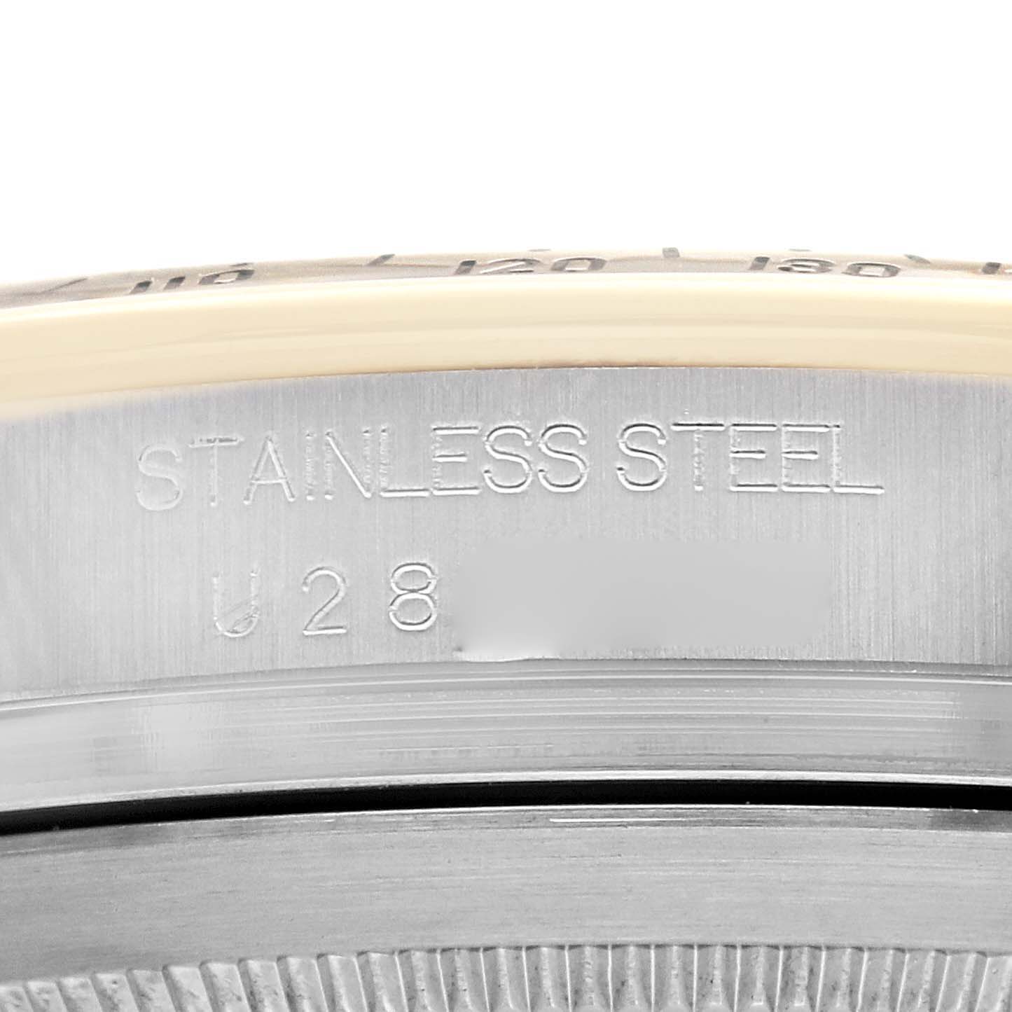 The image shows a close-up of the side casing and bezel of a Rolex Daytona 16523 Men's Steel and Gold (two tone) White Dial, highlighting its "Stainless Steel" engraving.