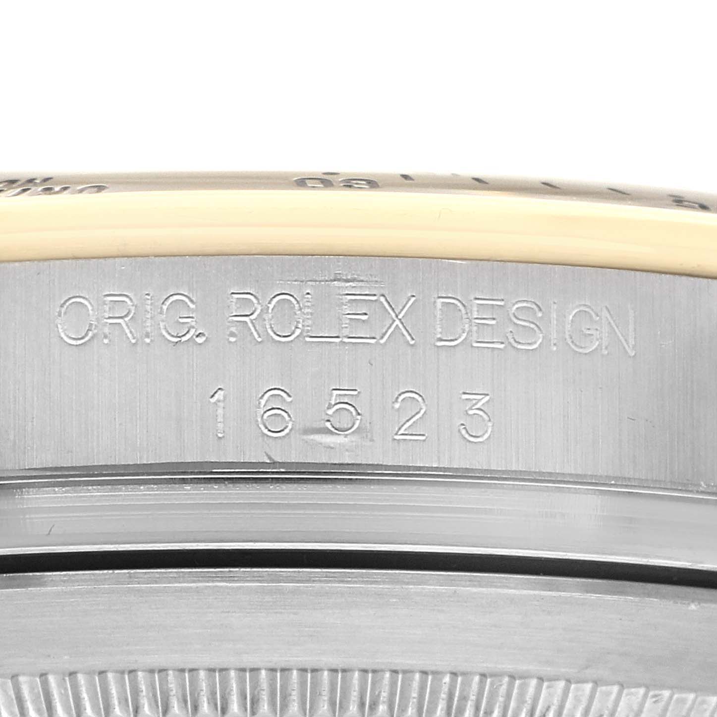 The image shows a close-up of the side of a Rolex Daytona 16523 Men's Steel and Gold (two tone) White Dial, displaying the engraved model number "16523" and "ORIG. ROLEX DESIGN."