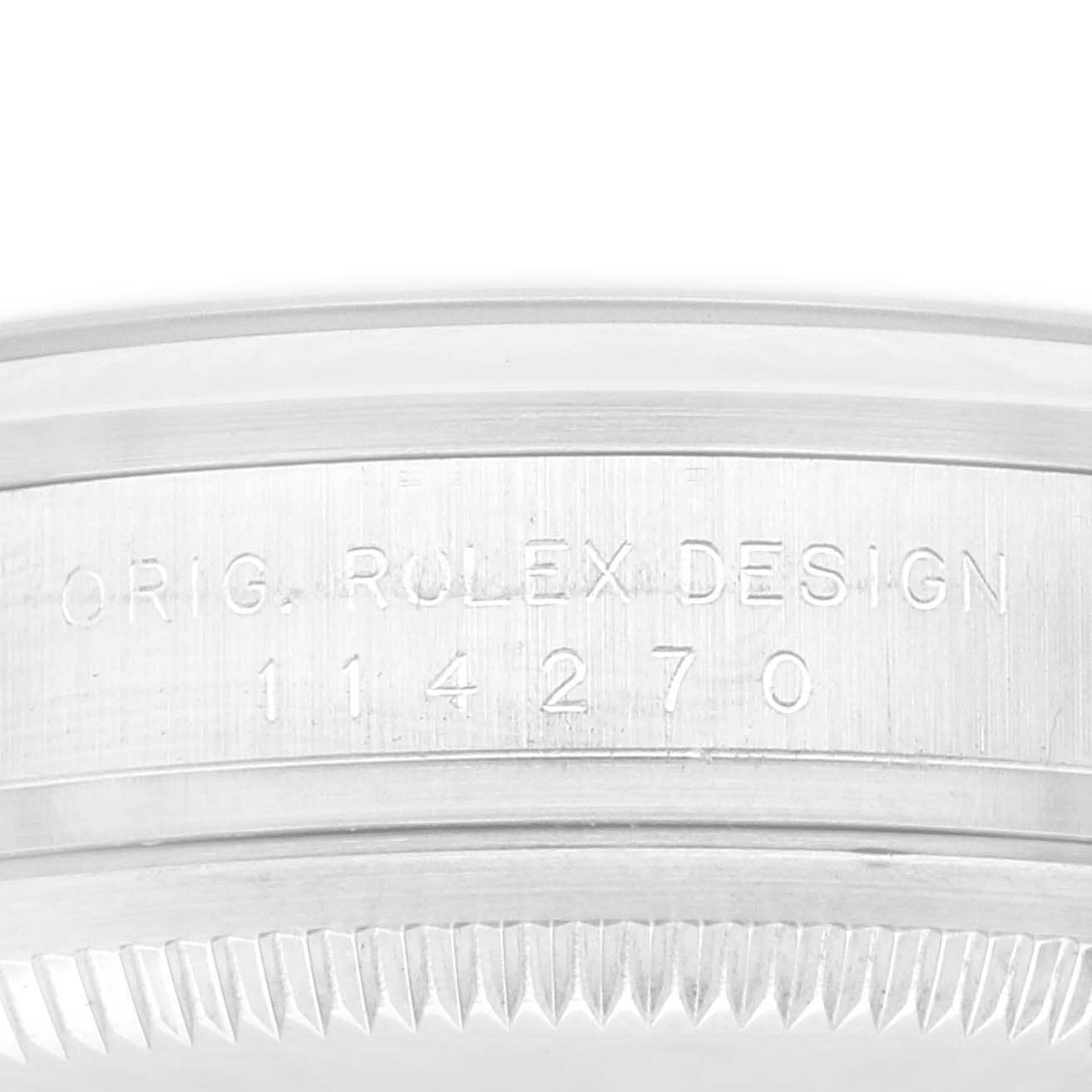 The image shows a close-up of the side casing of a Rolex Explorer 114270 Men
s Stainless Steel Black Dial 114270 Men
s Stainless Steel Black Dial watch, displaying the engraved text "ORIG. ROLEX DESIGN 114270."