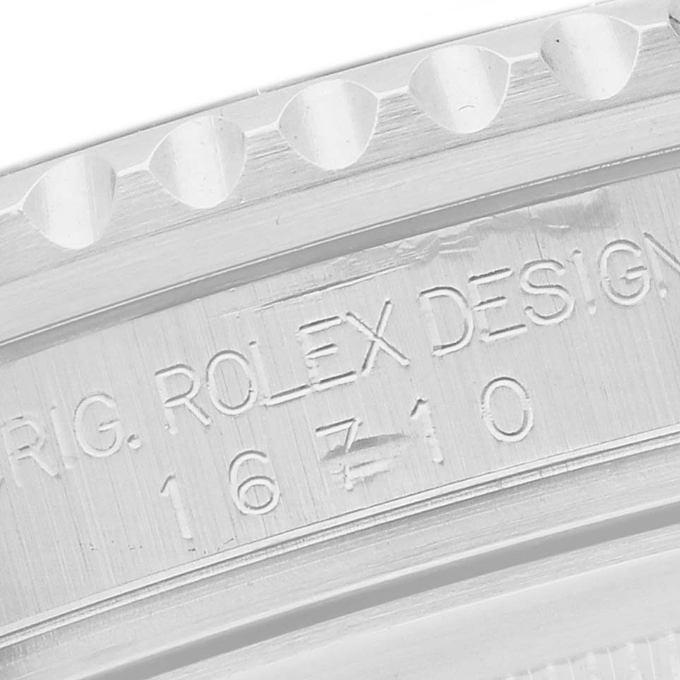 The image shows an angled close-up of the Rolex GMT-Master 16710 Men's Stainless Steel Black Dial's case engraving, featuring model and design details.