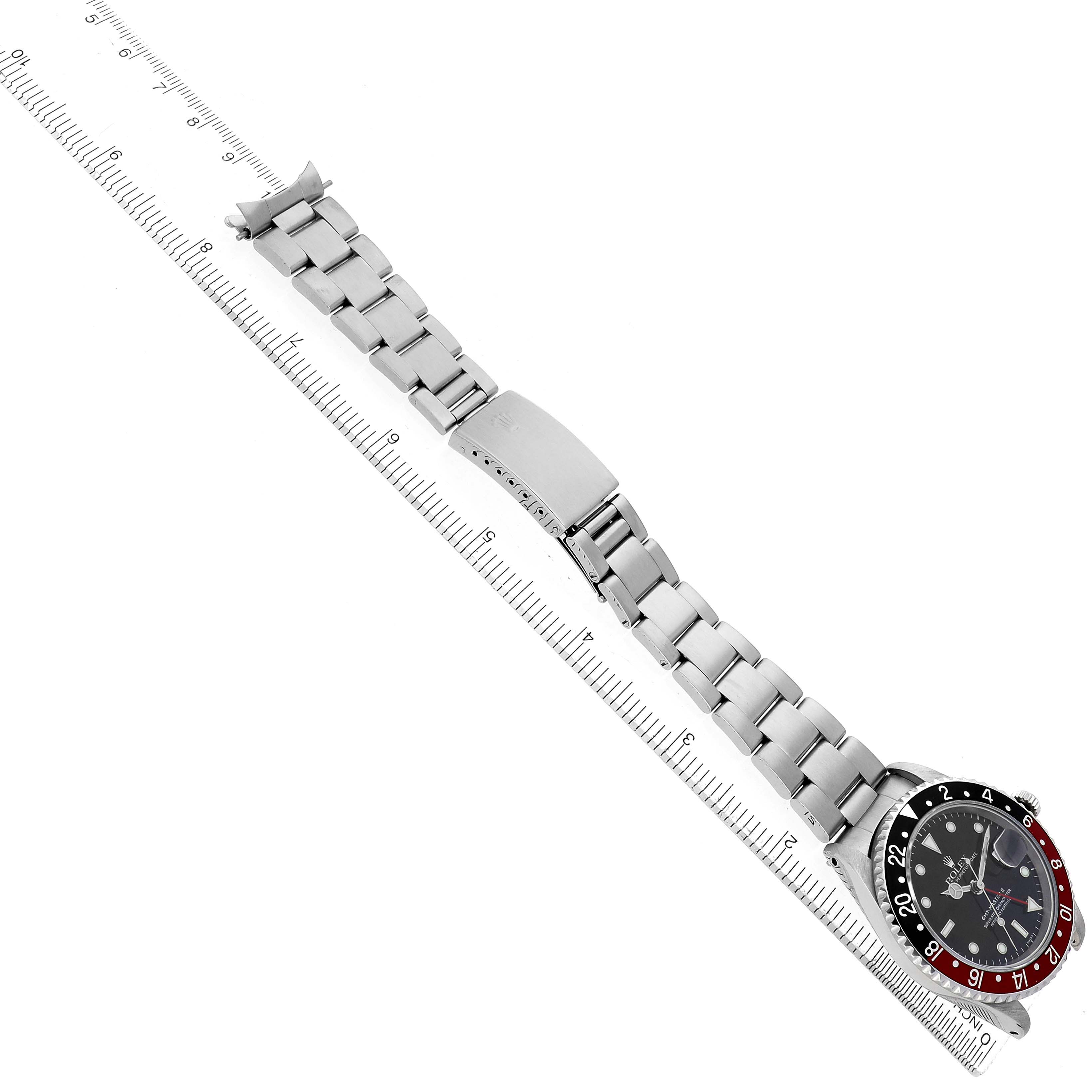The Rolex GMT-Master 16710 Men's Stainless Steel Black Dial watch is shown from a top view, displaying the bracelet, clasp, and bezel alongside a ruler.