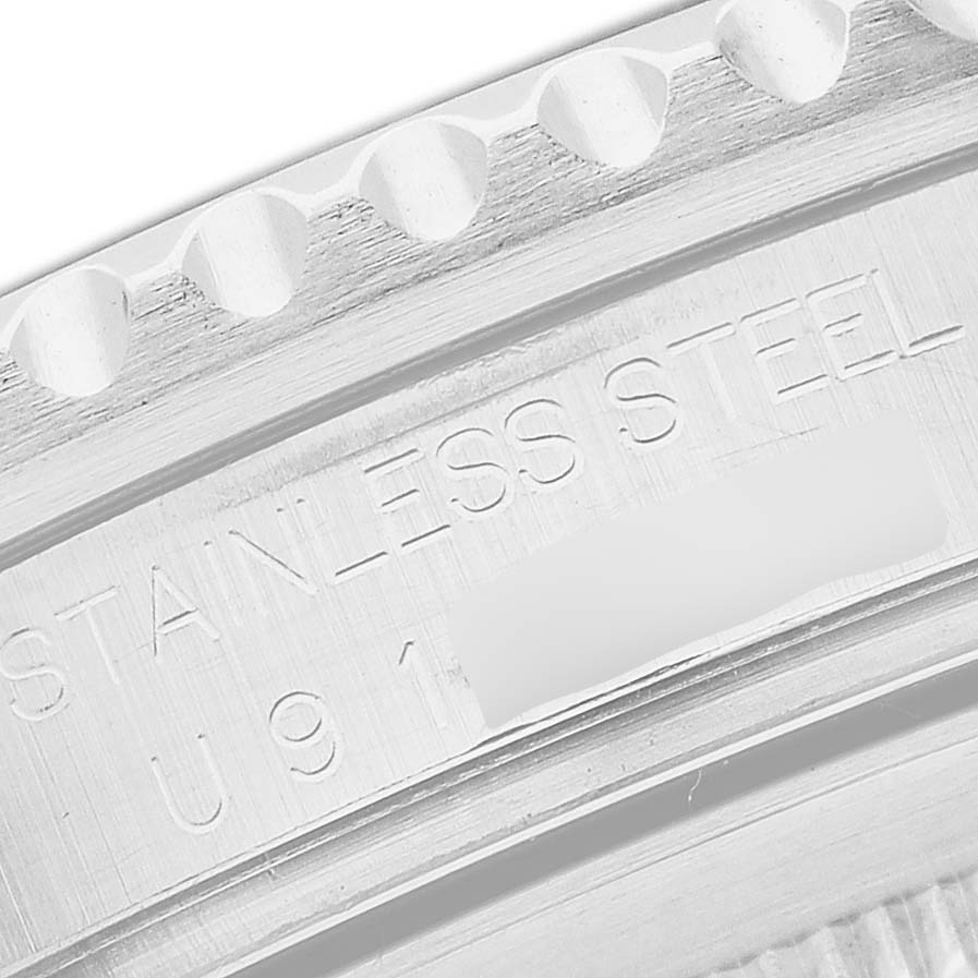 The image shows a close-up of the engraved case back edge of a Rolex GMT-Master 16710 Men's Stainless Steel Black Dial watch, highlighting the "STAINLESS STEEL" text.