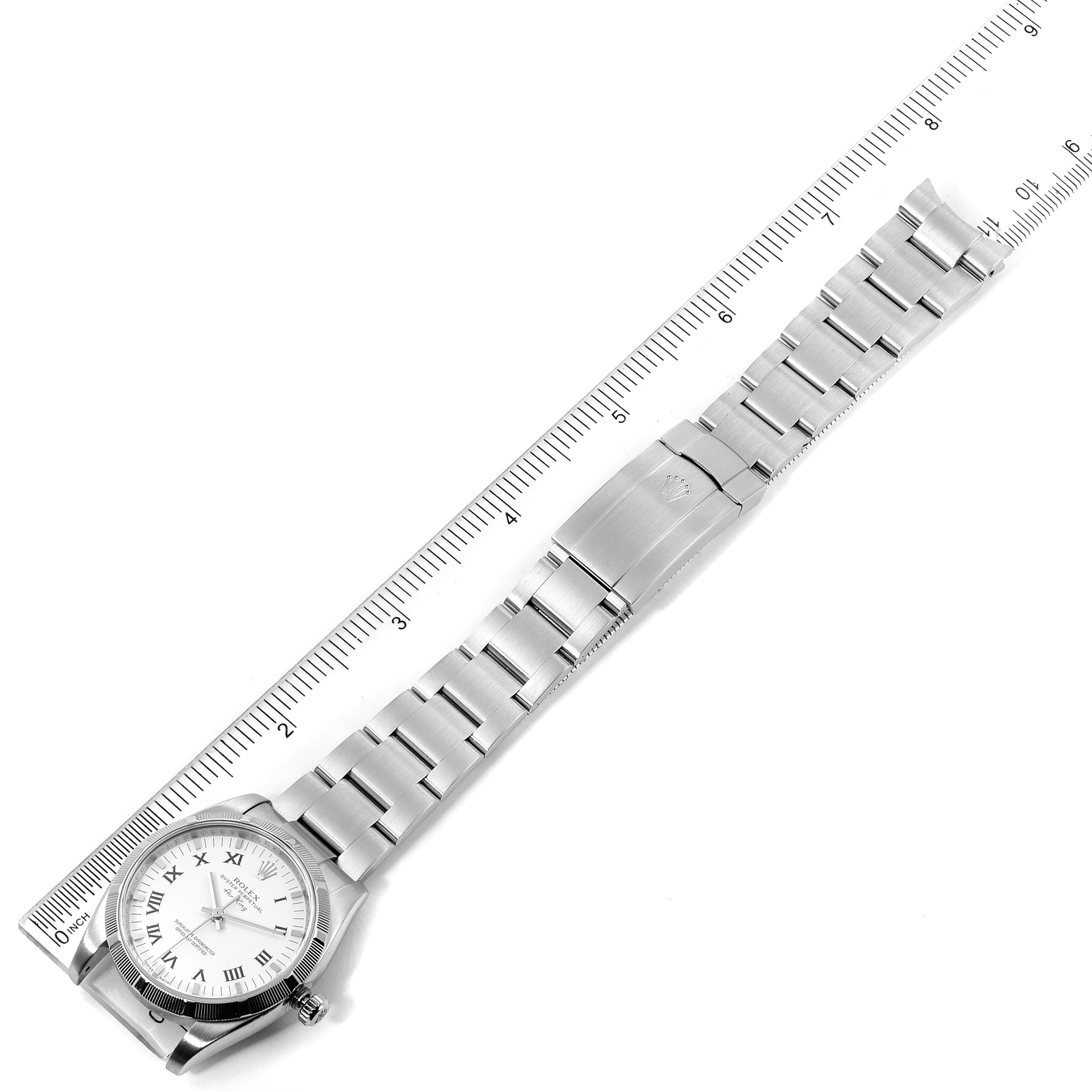 The image shows a top-down view of an entire Rolex Air-King 114210 Men's Stainless Steel White Dial 114210 Men's Stainless Steel White Dial watch, including the face and the metal bracelet with a ruler for scale.