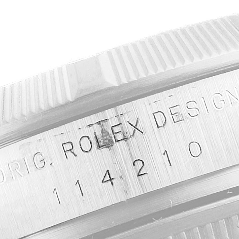 This close-up image shows the side of the case and part of the bezel of the Rolex Air-King 114210 Men's Stainless Steel White Dial 114210 Men's Stainless Steel White Dial watch, displaying its engraved serial number.