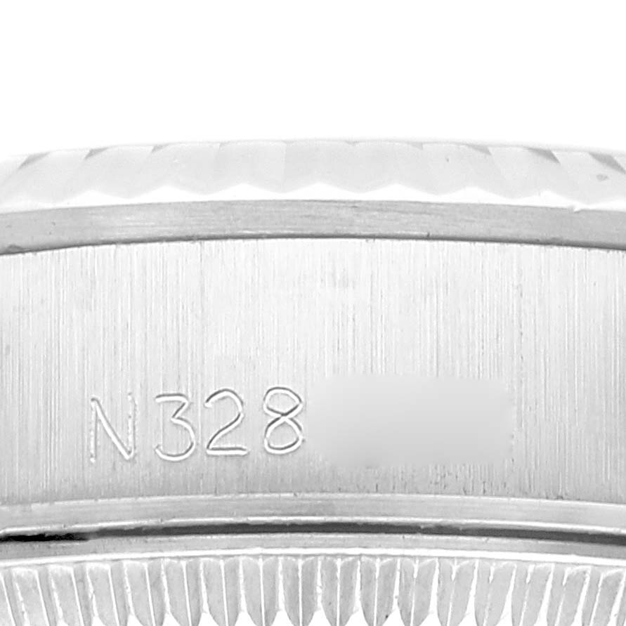 This close-up image shows the side view of the bezel and case of a Rolex Oyster Perpetual 67194 Women's Stainless Steel Blue Dial 67194 Women's Stainless Steel Blue Dial watch, displaying part of its serial number.
