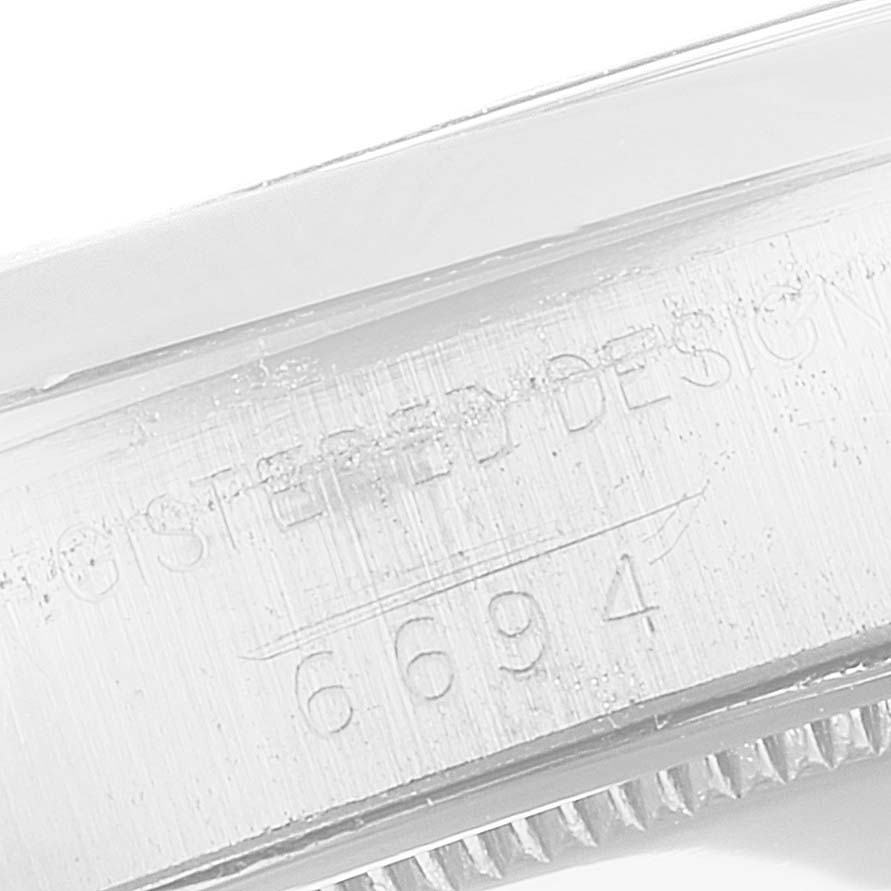 This image shows a close-up of the engraved serial number and part of the case of a Rolex Vintage Collection 6694 Men's Stainless Steel Brown Dial 6694 Men's Stainless Steel Brown Dial model 6694.