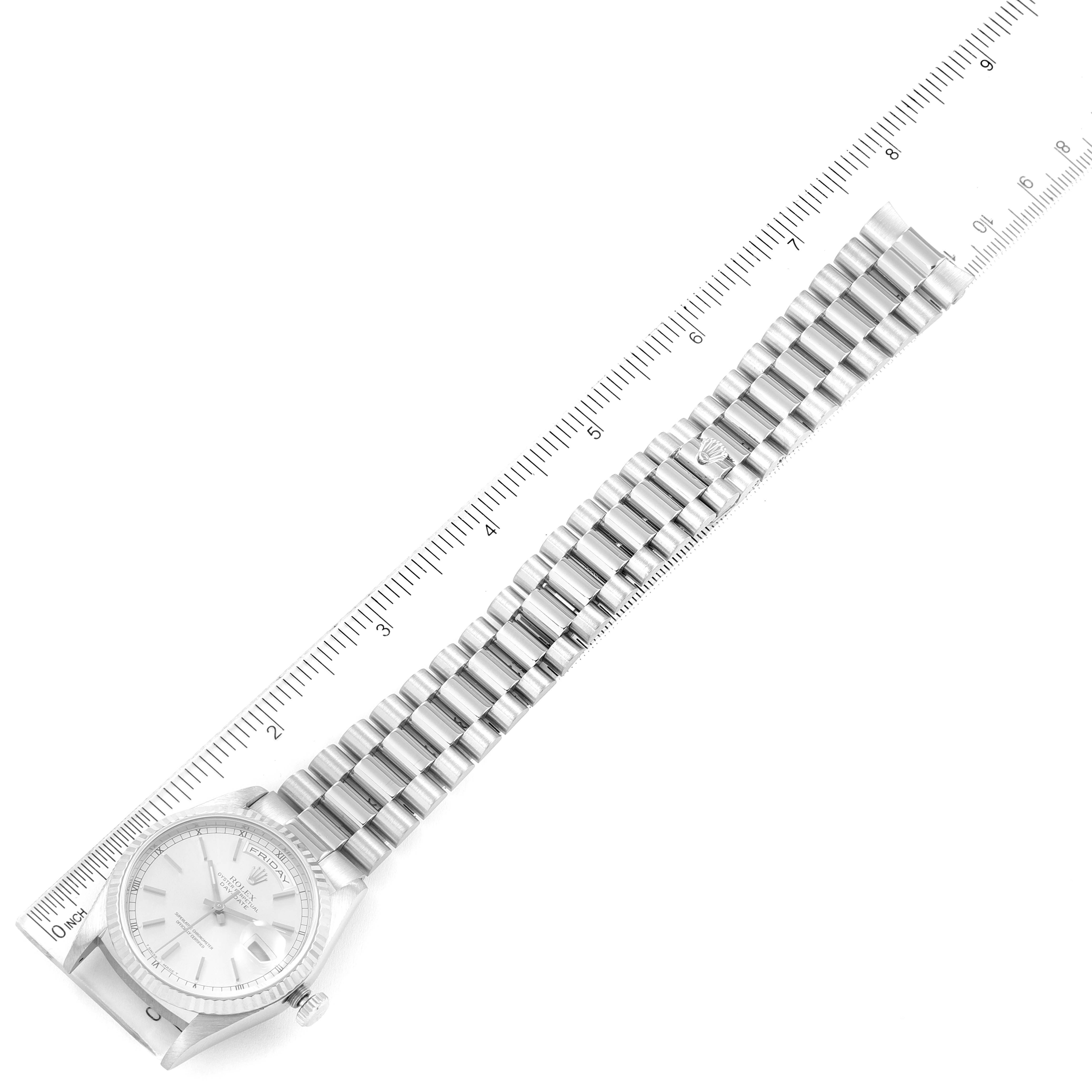 This image shows a Rolex President 18239 Men
s White Gold Silver Dial 18239 Men
s White Gold Silver Dial model watch from a top-down angle, displaying the face and metal bracelet alongside a ruler for scale.