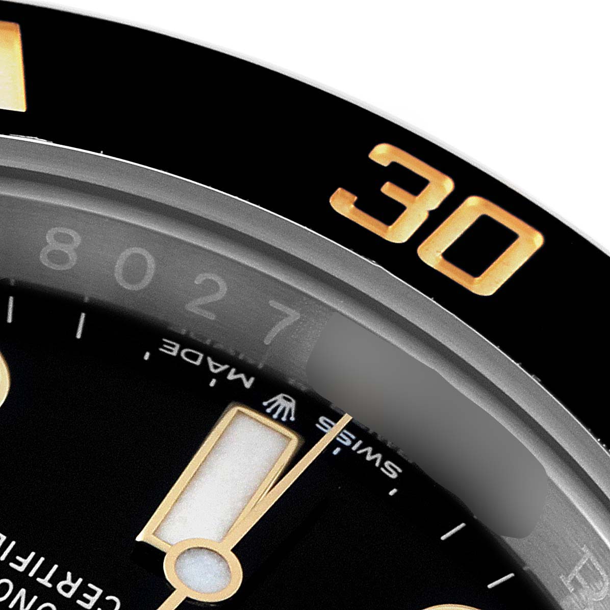 This close-up angle of the Rolex Submariner 126613 Men's Steel and Gold (two tone) Black Dial 126613 Men's Steel and Gold (two tone) Black Dial watch shows part of the bezel and the hour markers on the dial.