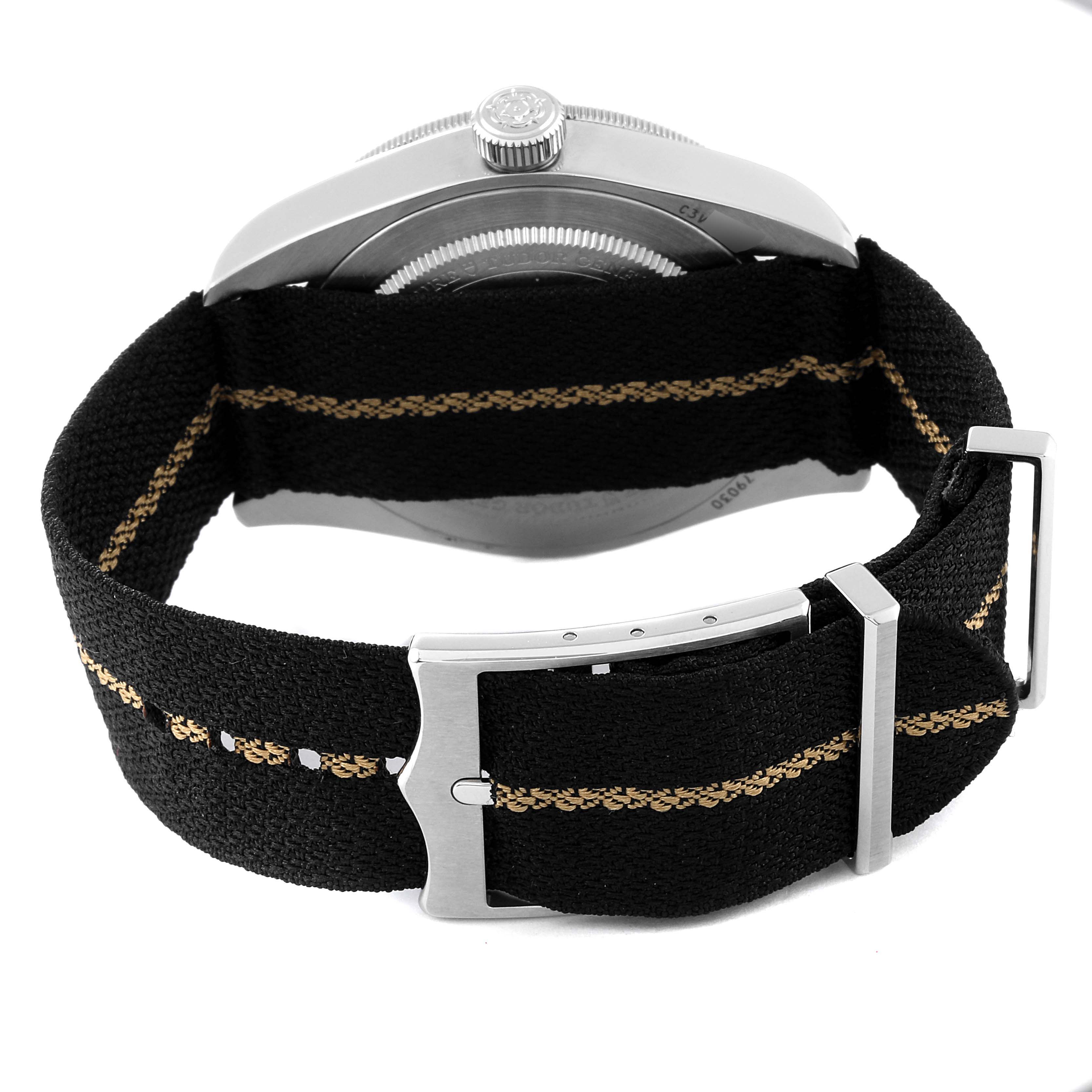 The image displays the back of a Tudor Heritage Black Bay 79030N Men's Stainless Steel Black Dial 79030N Men's Stainless Steel Black Dial watch with a black fabric strap and silver clasp.