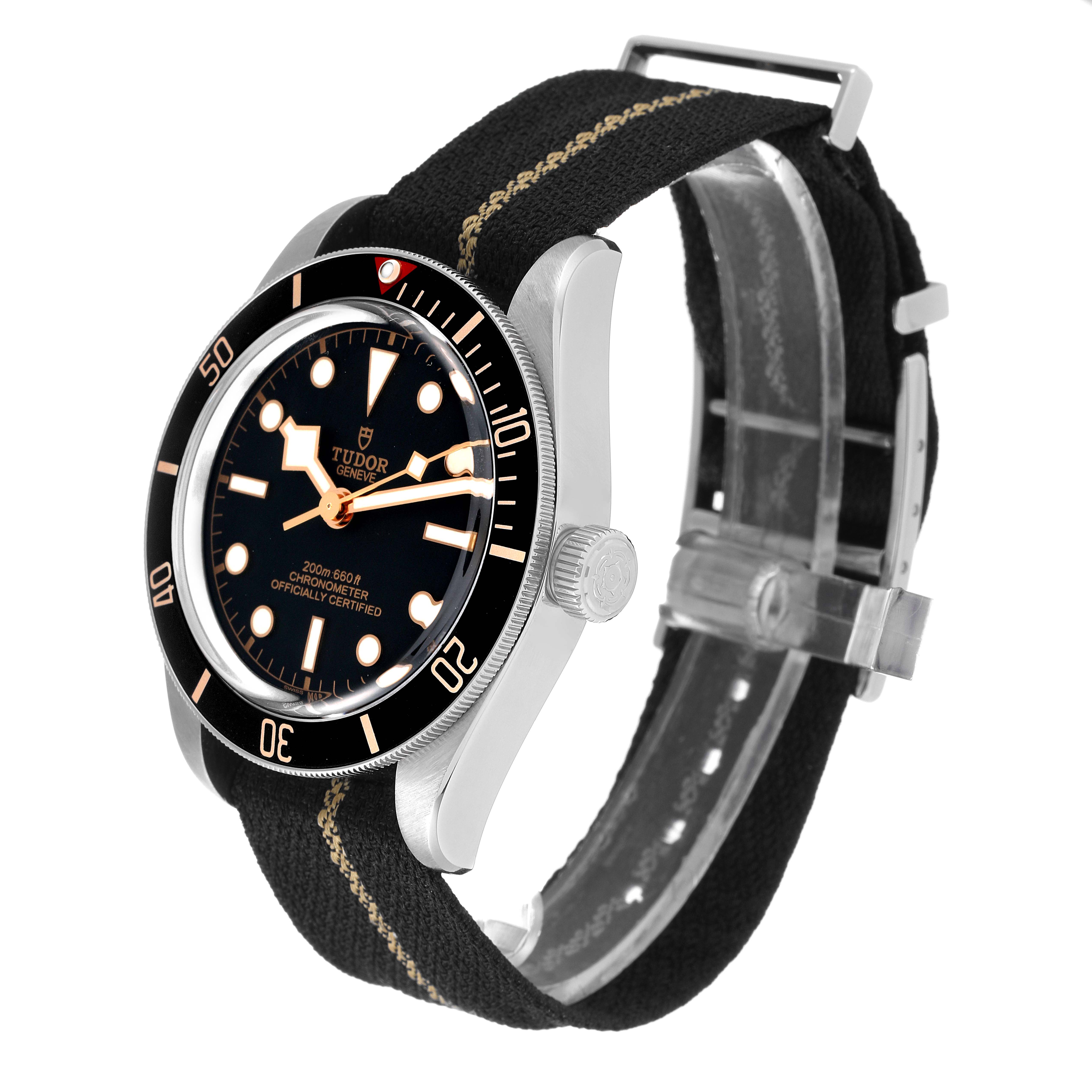 The Tudor Heritage Black Bay 79030N Men's Stainless Steel Black Dial 79030N Men's Stainless Steel Black Dial watch is shown from a three-quarter front angle, displaying the face, bezel, crown, and fabric strap with clasp.
