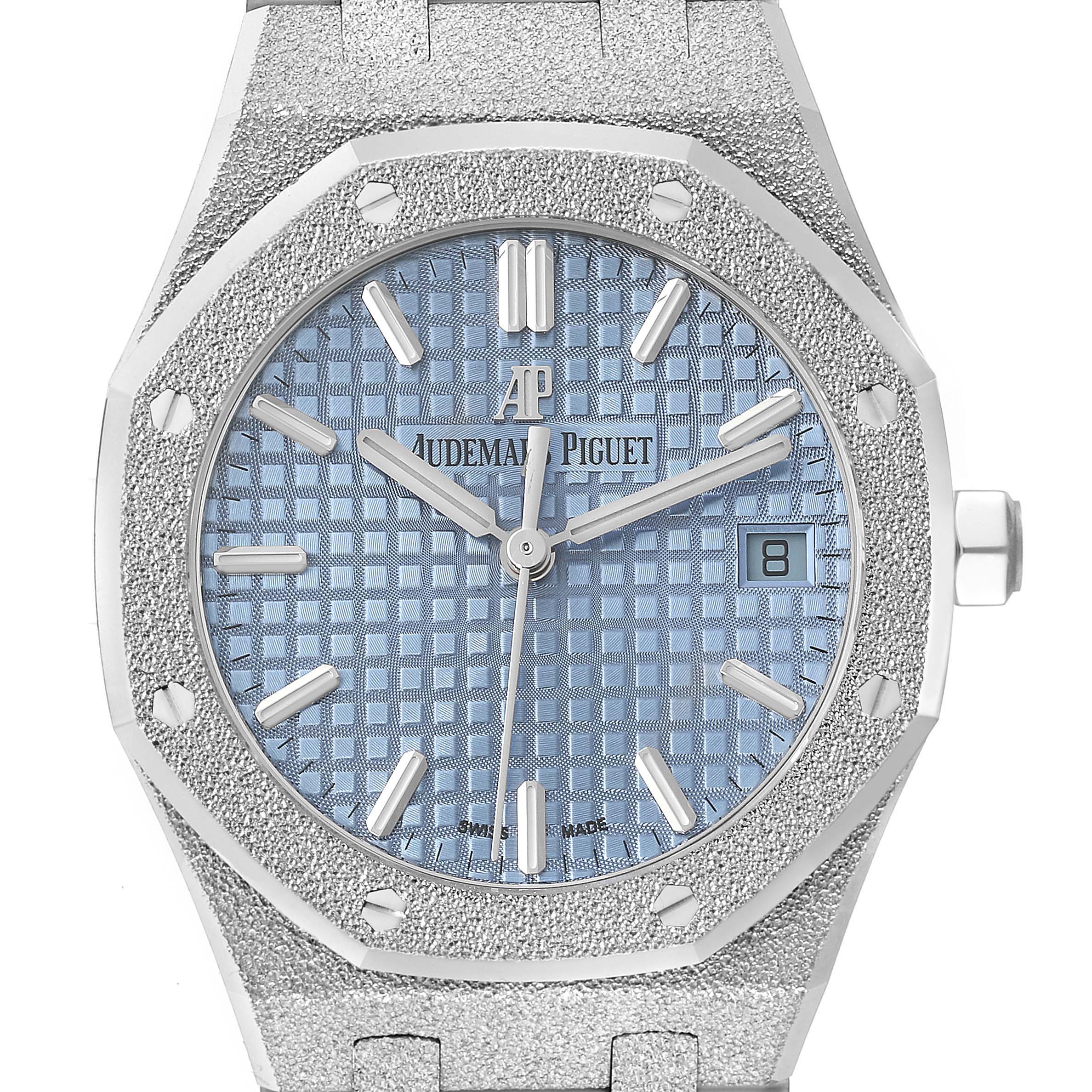 The image shows a front-facing angle of an Audemars Piguet Royal Oak 77353BC.GG.1263BC.01 Women's White Gold Blue Dial 77353BC.GG.1263BC.01 Women's White Gold Blue Dial watch, featuring its dial, hands, date window, and textured bracelet.