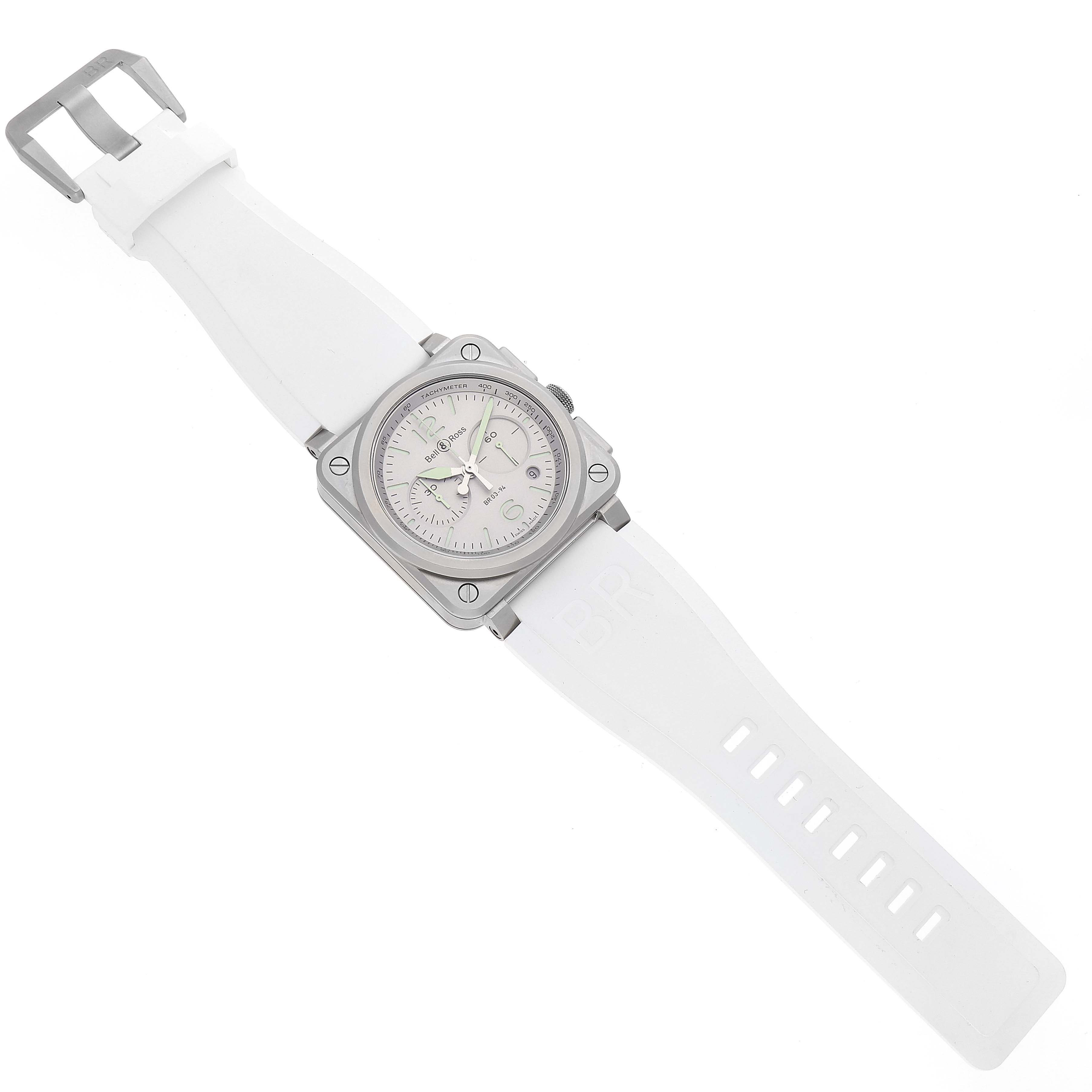 The image shows a top-down view of the Bell & Ross Chronograph model, including the watch face, bezel, and white strap.