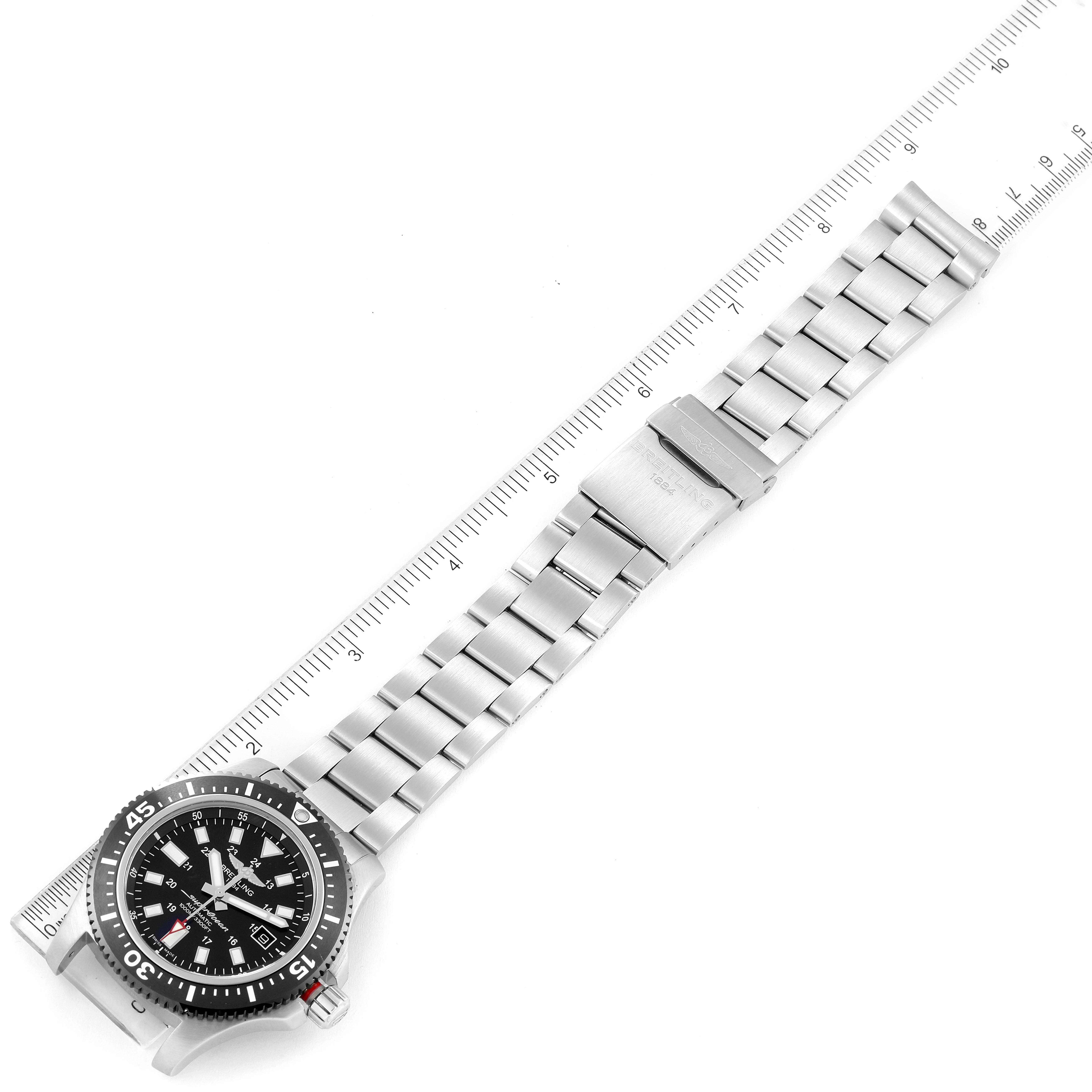 The image shows a Breitling Superocean Y17393 Men's Stainless Steel Black Dial Y17393 Men's Stainless Steel Black Dial watch laid flat, measured against a ruler, showcasing its dial, bezel, and metal bracelet.