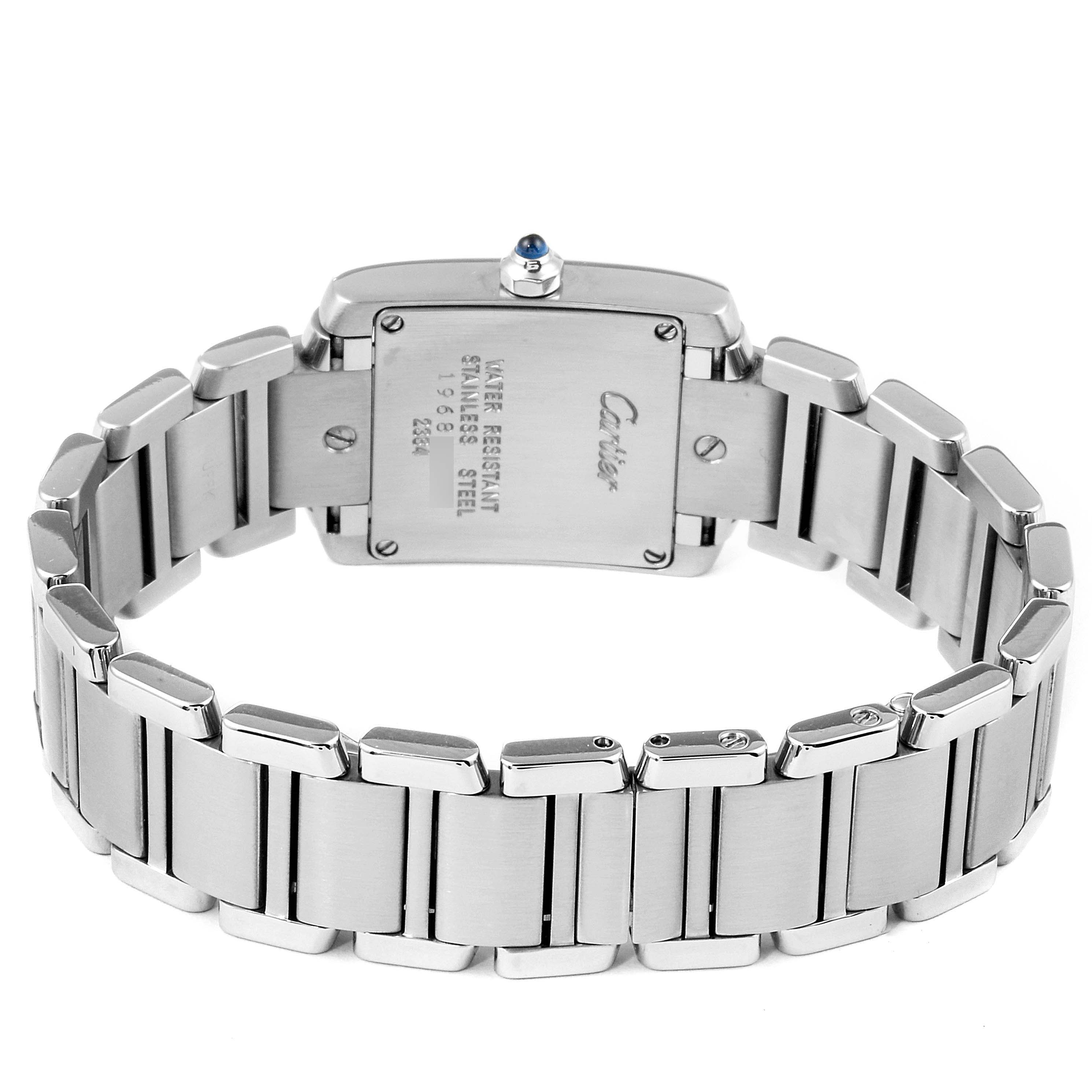 The image shows the back view of a Cartier Tank Française watch, highlighting its stainless steel bracelet and case back.