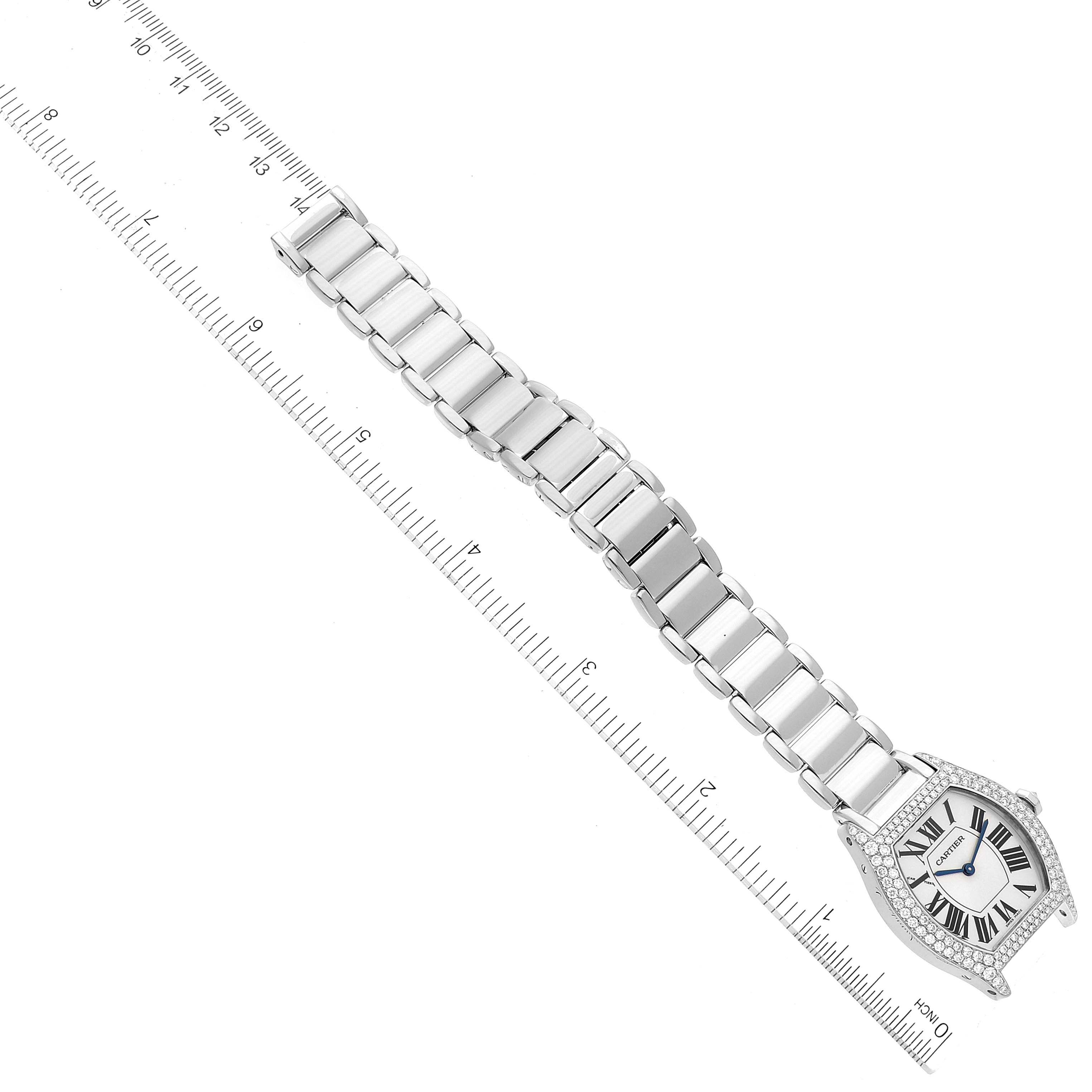 This image shows a Cartier Tortue WA5072W9 Women's White Gold Silver Dial WA5072W9 Women's White Gold Silver Dial watch from a top view, displaying the entire face and metal band alongside a ruler for measurement.