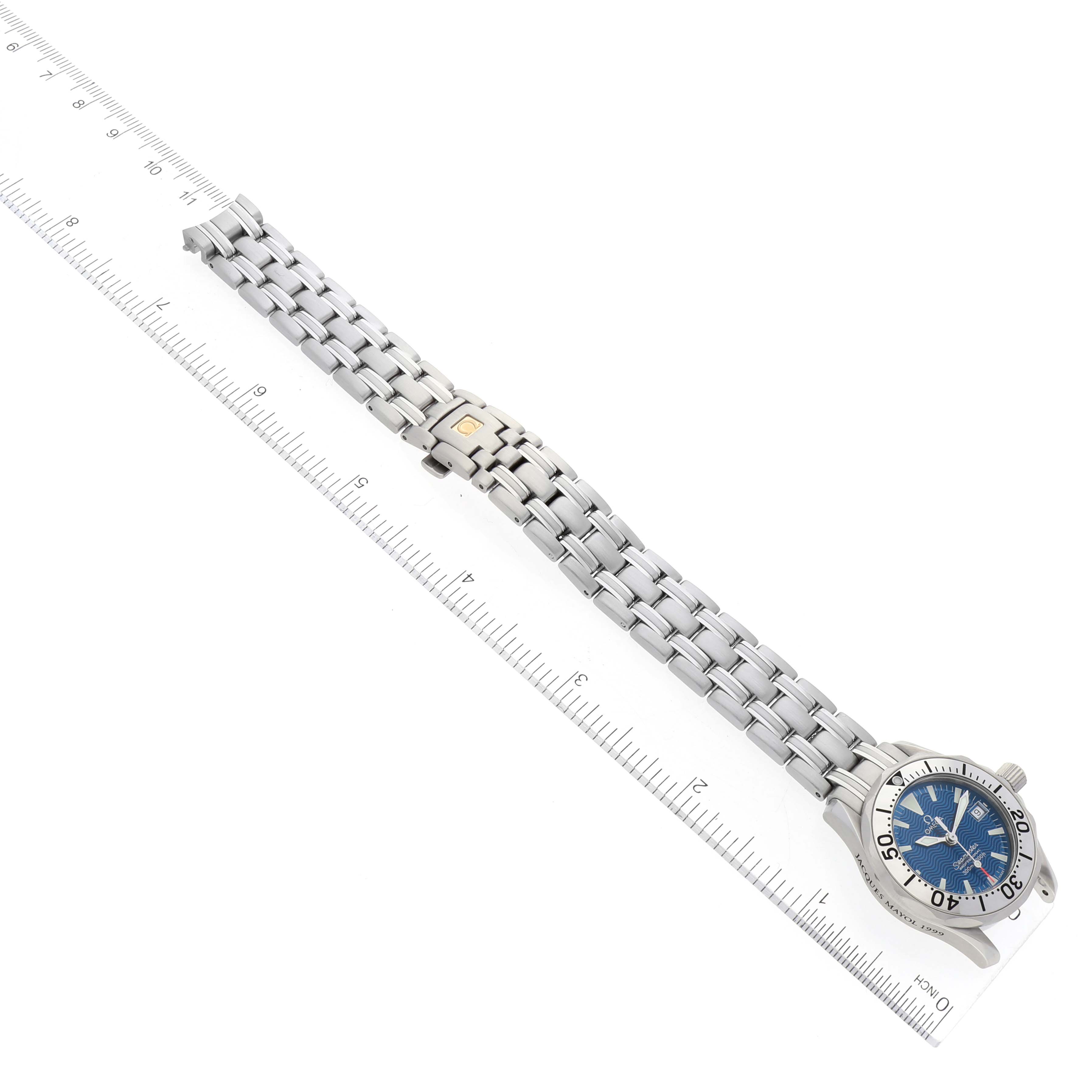 This image shows the Omega 2584.80.00 Women's Stainless Steel Blue Dial 2584.80.00 Women's Stainless Steel Blue Dial Seamaster Diver 300M Quartz 28mm Steel Ladies Watch 2584.80.00, laid flat, facing upward, with a ruler for scale.