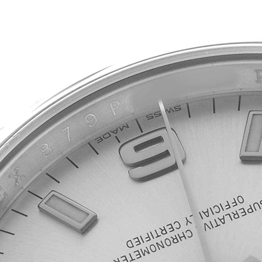 The image shows a close-up of the dial, indices, hands, and partial bezel of a Rolex Oyster Perpetual 114200 Men's Stainless Steel Silver Dial watch.