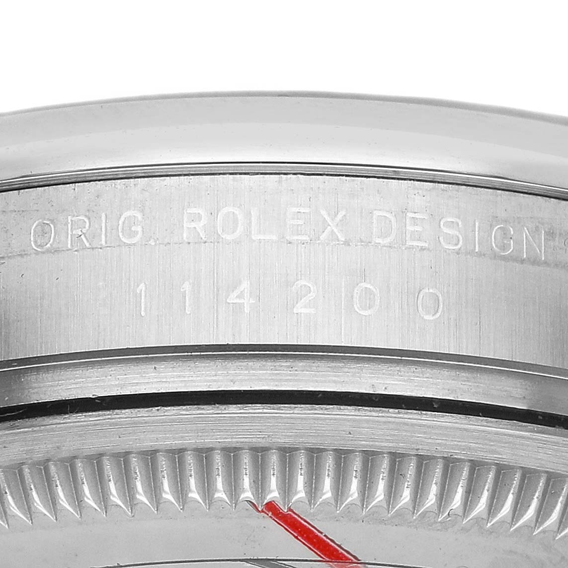 The image shows a close-up of the side of a Rolex Oyster Perpetual 114200 Men's Stainless Steel Silver Dial watch, highlighting the case with engraved model details.