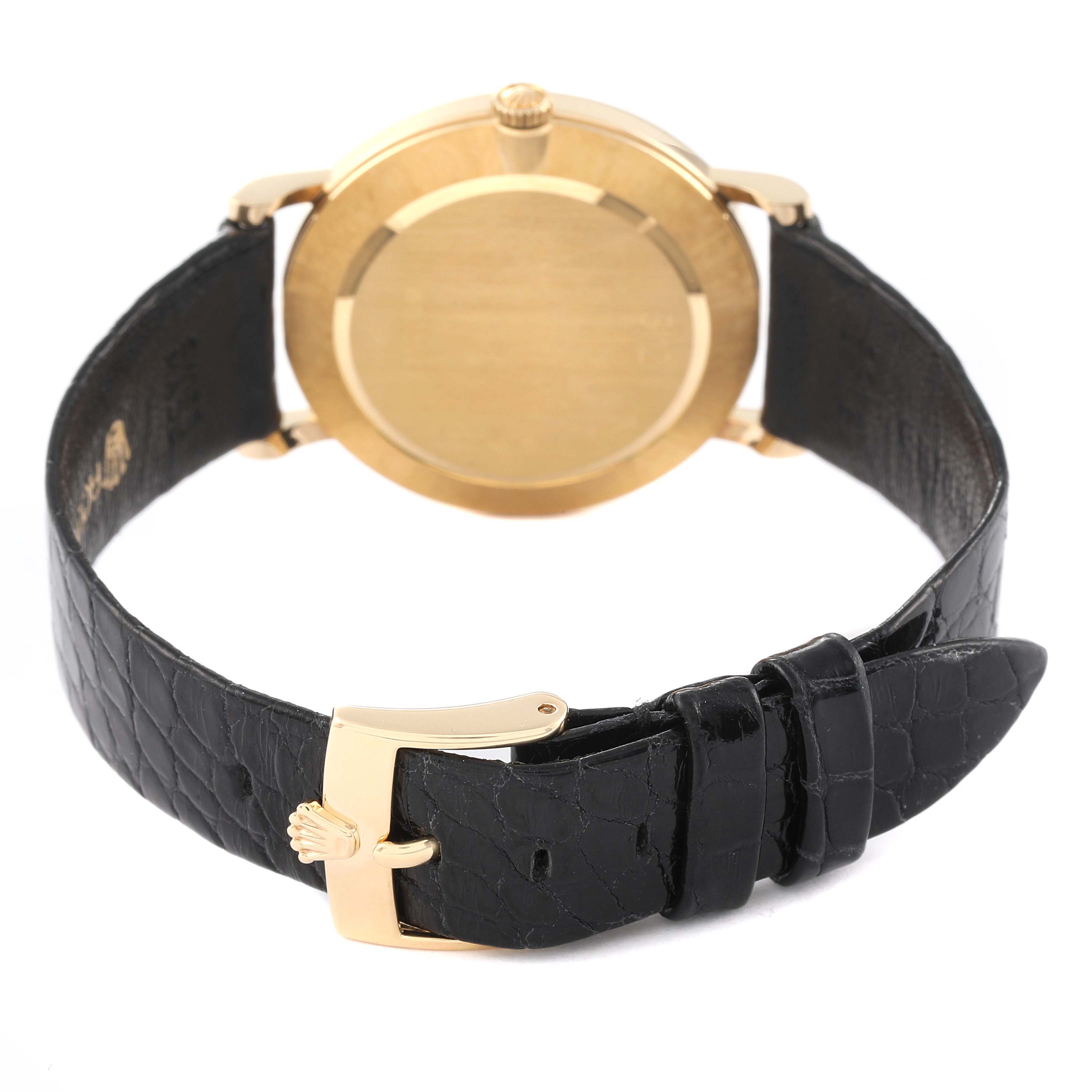 This image shows the back view of a Rolex Cellini 5112 Men
s Yellow Gold Silver Dial 5112 Men
s Yellow Gold Silver Dial watch with a gold case and a black leather strap.