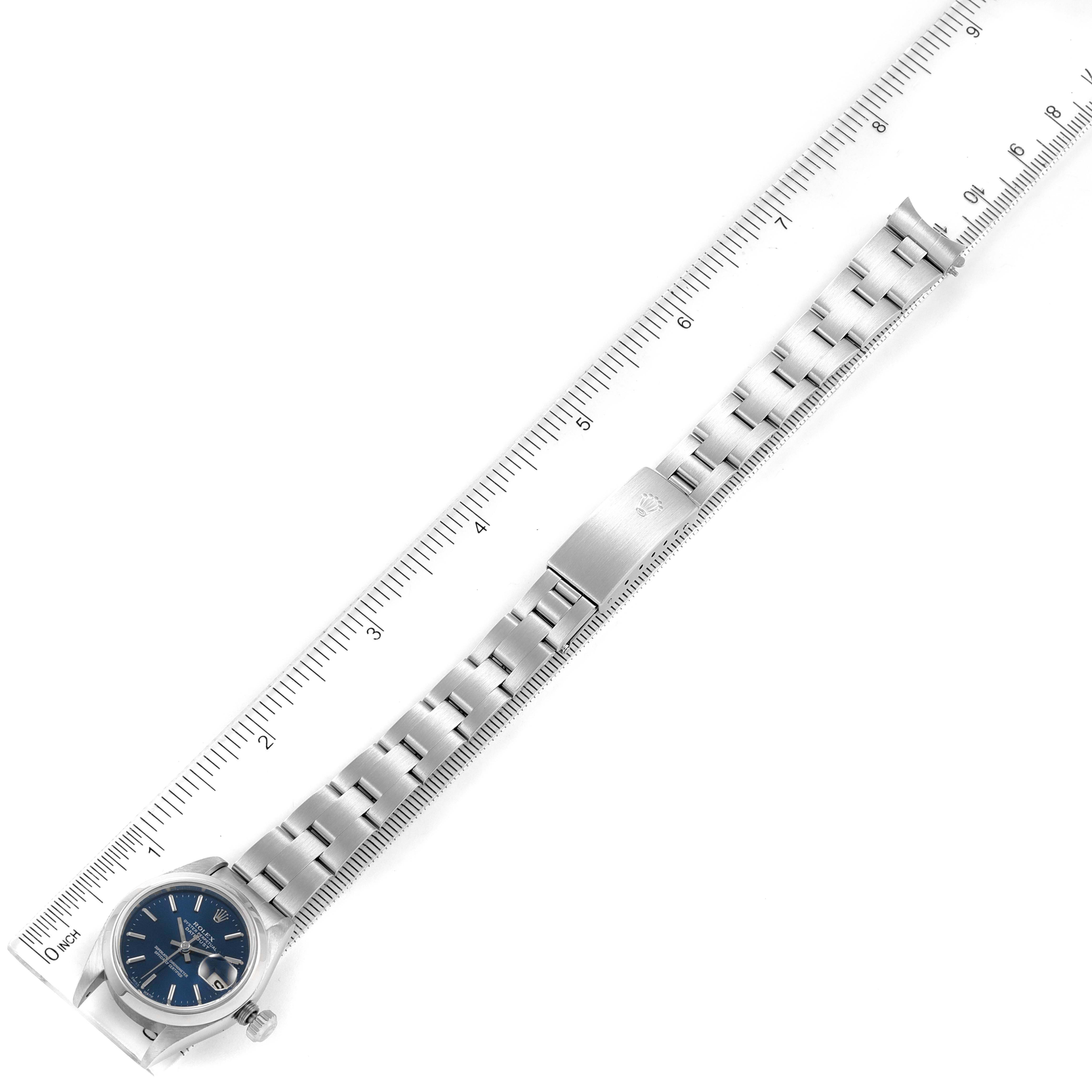This image shows a Rolex Date 69160 Women's Stainless Steel Blue Dial 69160 Women's Stainless Steel Blue Dial model watch laid flat, highlighting its face, bracelet, and clasp next to a ruler for scale.