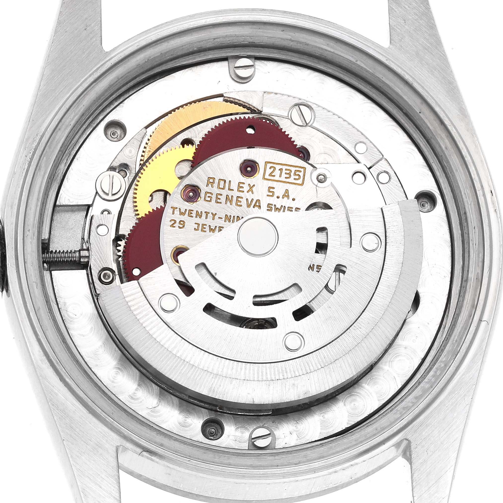 The image shows the back of the mid-size Rolex watch, displaying its movement and inner mechanisms.