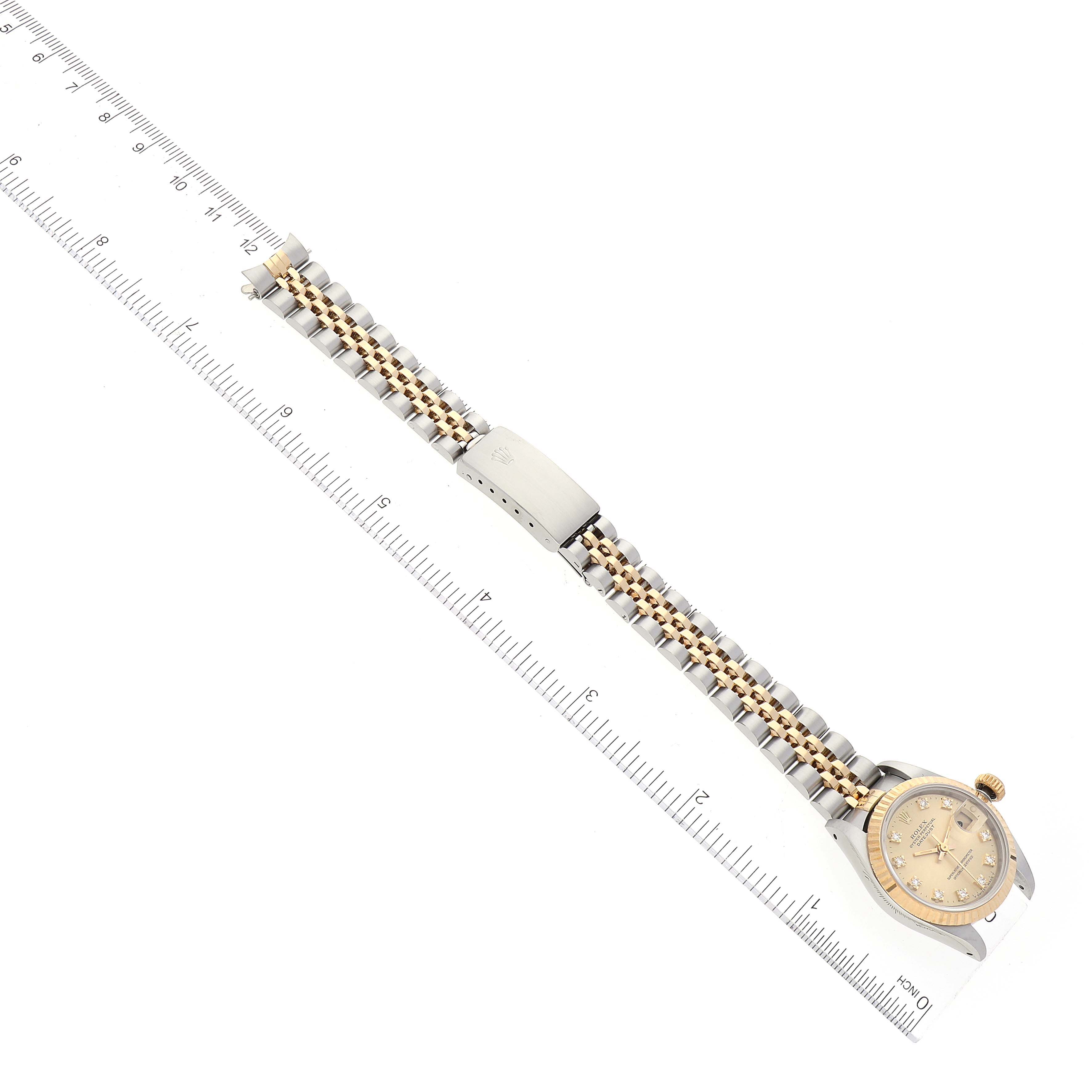 The image shows a top-down view of a Rolex Datejust 69173 Women's Steel and Gold (two tone) Champagne Dial 69173 Women's Steel and Gold (two tone) Champagne Dial watch, displaying the face, bracelet, and clasp alongside a ruler for scale.