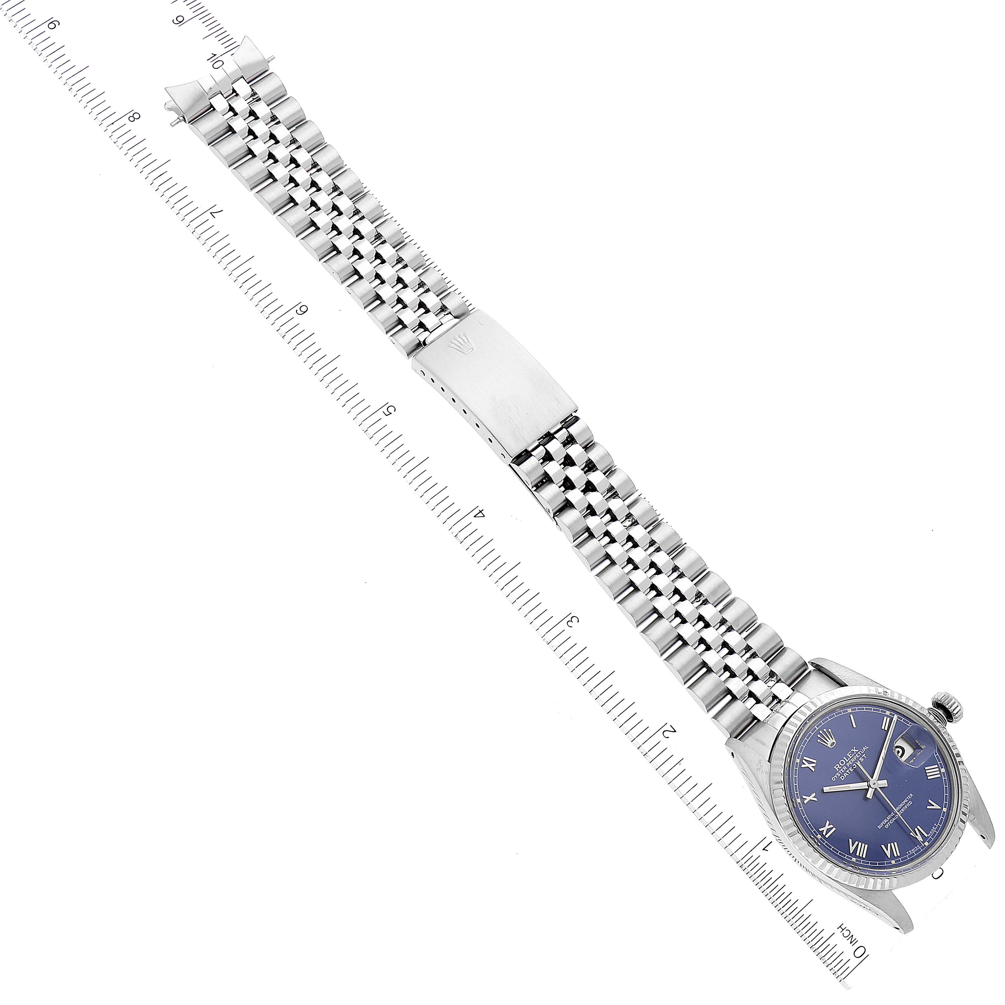 The image shows a Rolex Datejust 16014 Men's Stainless Steel Blue Dial 16014 Men's Stainless Steel Blue Dial watch fully extended with a jubilee bracelet and a blue dial, placed next to a ruler for size reference.