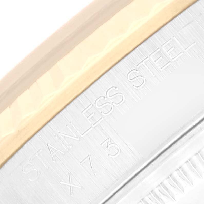 This close-up image shows the stainless steel part of a Rolex Datejust 16233 Men's Steel and Gold (two tone) Black Dial 16233 Men's Steel and Gold (two tone) Black Dial watch with engraved text.
