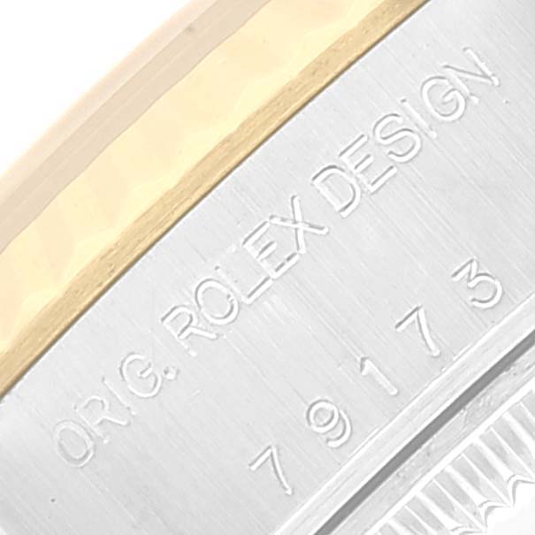 This close-up image shows the side engraving of a Rolex Datejust 79173 Women's Steel and Gold (two tone) Champagne Dial 79173 Women's Steel and Gold (two tone) Champagne Dial watch, featuring the model number and "ORIG. ROLEX DESIGN" text.