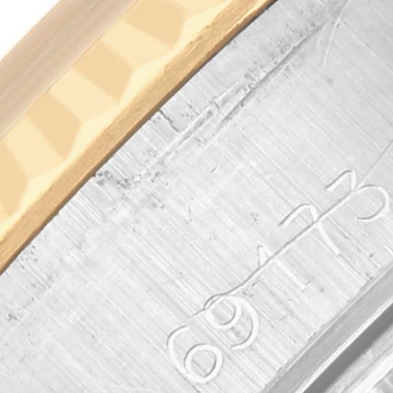 The image shows a close-up of the fluted bezel and engraved serial number on a Rolex Datejust 69173 Women's Steel and Gold (two tone) Champagne Dial 69173 Women's Steel and Gold (two tone) Champagne Dial watch.