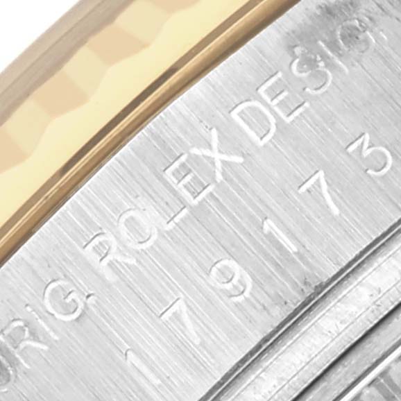 The image shows a close-up of the side engraving on a Rolex Datejust 179173 Women's Steel and Gold (two tone) Mother of Pearl Dial 179173 Women's Steel and Gold (two tone) Mother of Pearl Dial watch case.