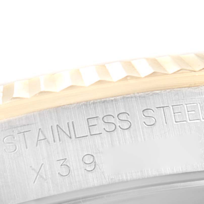 This close-up image shows the fluted bezel and part of the watch case with engraved text on a Rolex Datejust 16233 Men's Steel and Gold (two tone) Beige Dial 16233 Men's Steel and Gold (two tone) Beige Dial model.