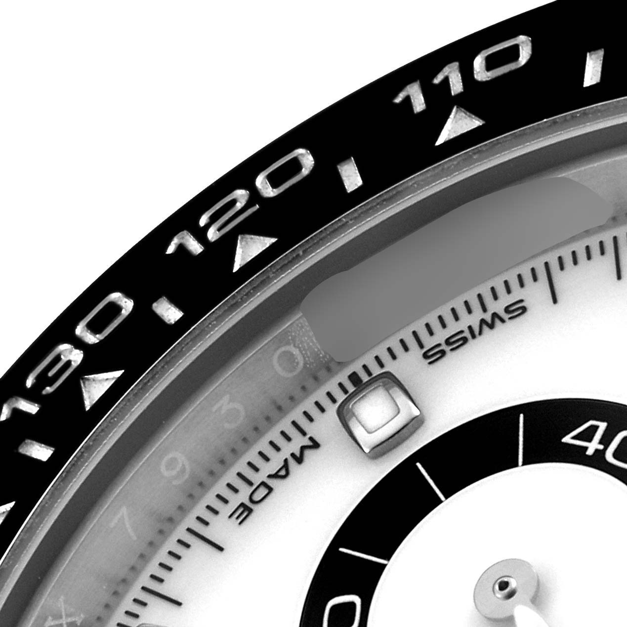 The image shows a close-up of the bezel and part of the dial of a Rolex Daytona 116500 Men's Stainless Steel White Dial 116500 Men's Stainless Steel White Dial watch.