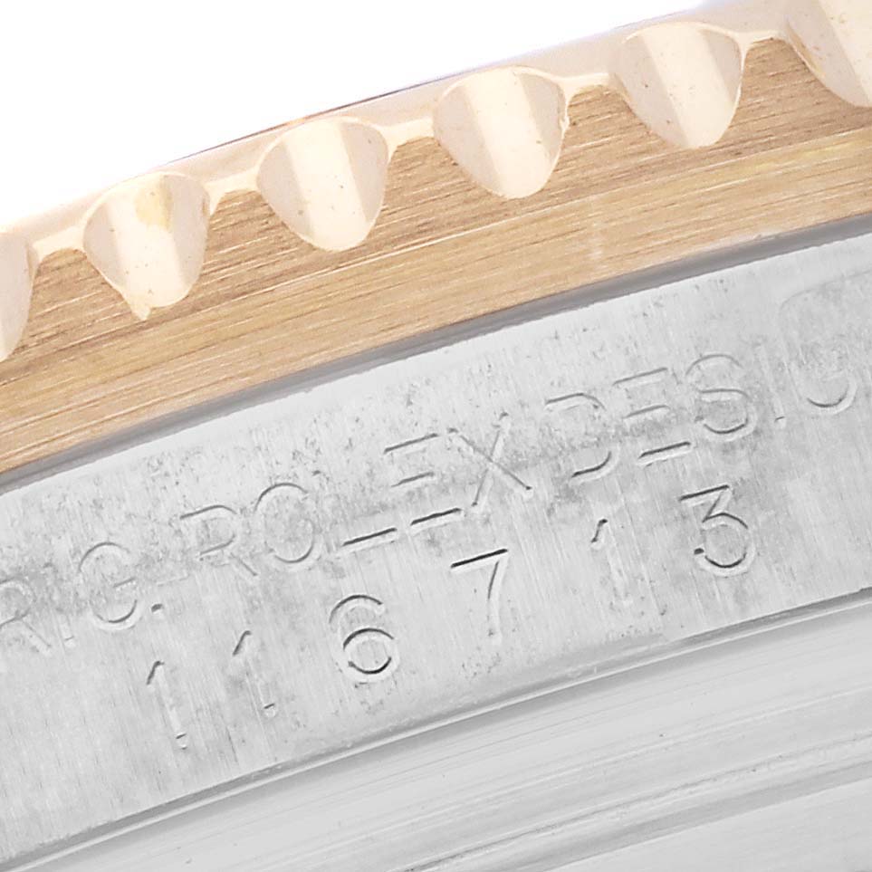 The image shows a close-up of the bezel and engraved case side of a Rolex GMT-Master 116713LN Men's Steel and Gold (two tone) Black Dial 116713LN Men's Steel and Gold (two tone) Black Dial watch.