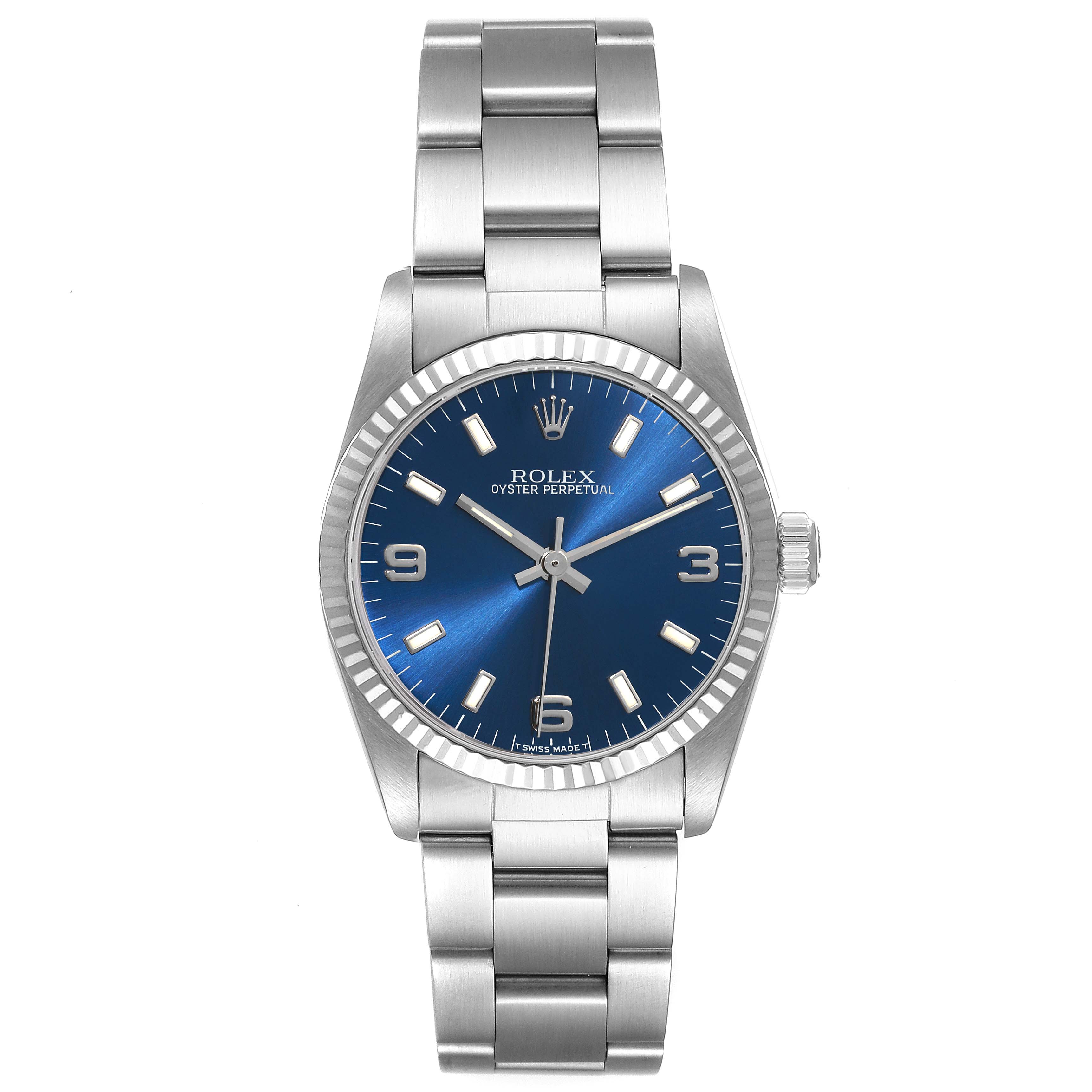 The image displays a front view of a Rolex Oyster Perpetual Mid-Size watch showing the blue dial and metal bracelet.