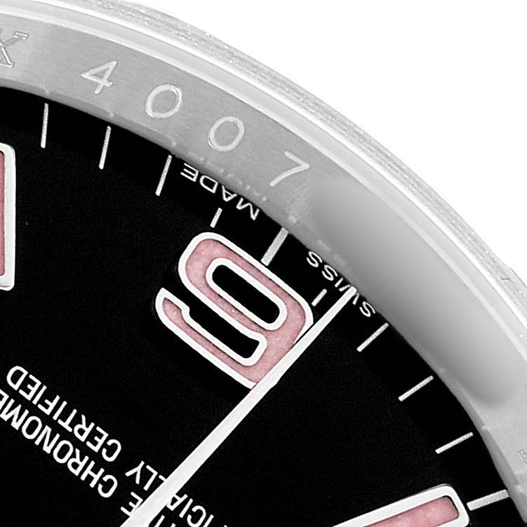 The image shows a close-up of the Rolex Oyster Perpetual 116000 Men's Stainless Steel Black Dial watch, focusing on a portion of the dial, the bezel, and the number "9".