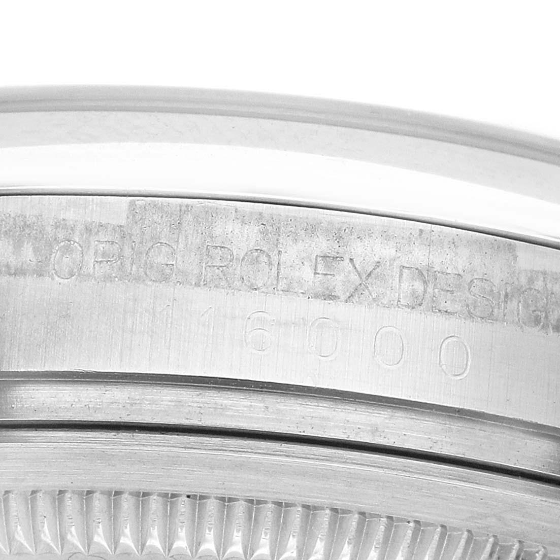 The image shows a close-up of the side of an Oyster Perpetual Rolex, highlighting the engraved serial number and bezel edge.