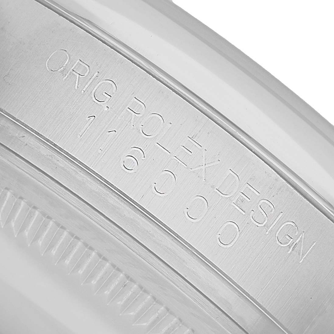 The image shows a close-up of the side engraving on a Rolex Oyster Perpetual 116000 Men's Stainless Steel Silver Dial, featuring the serial number and "ORIG. ROLEX DESIGN."