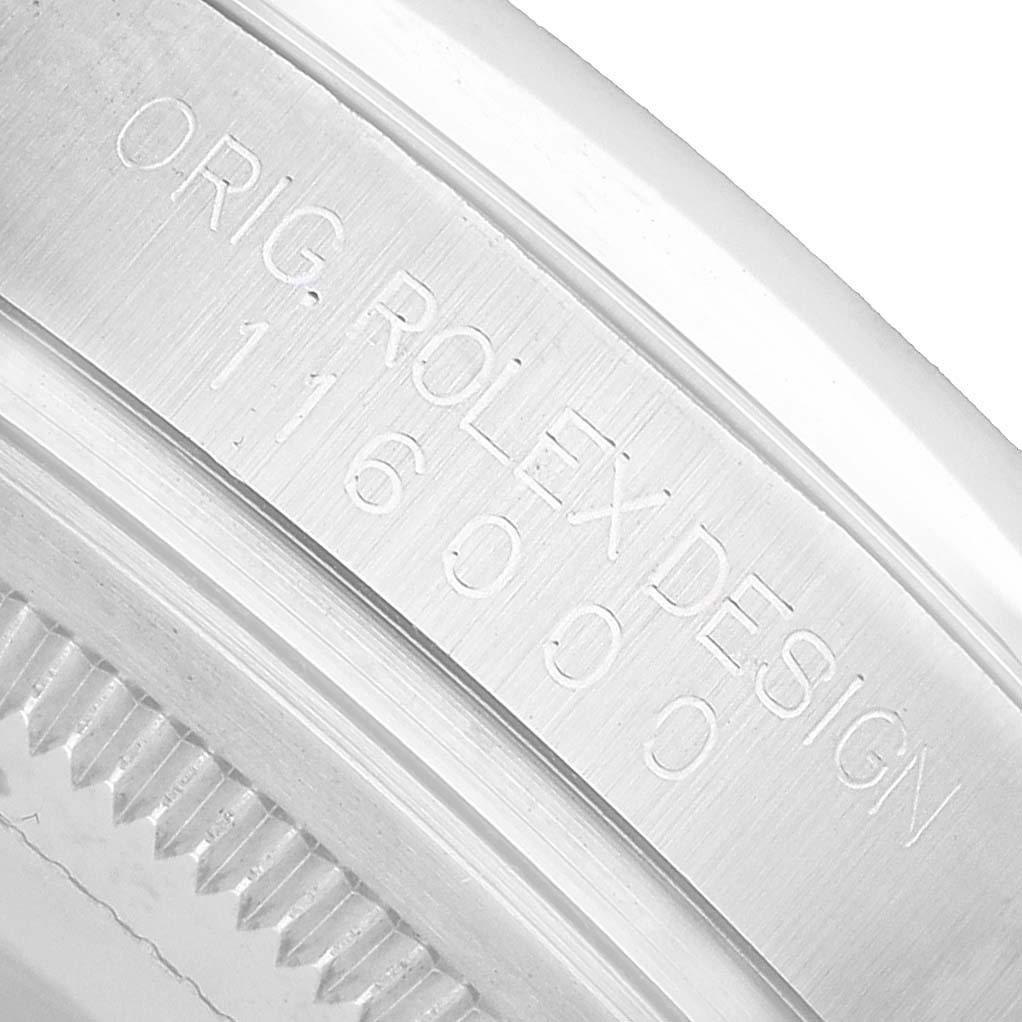 A close-up angle shows the case engraving of a Rolex Oyster Perpetual 116000 Men's Stainless Steel Blue Dial watch with "Orig Rolex Design 116000" inscribed.