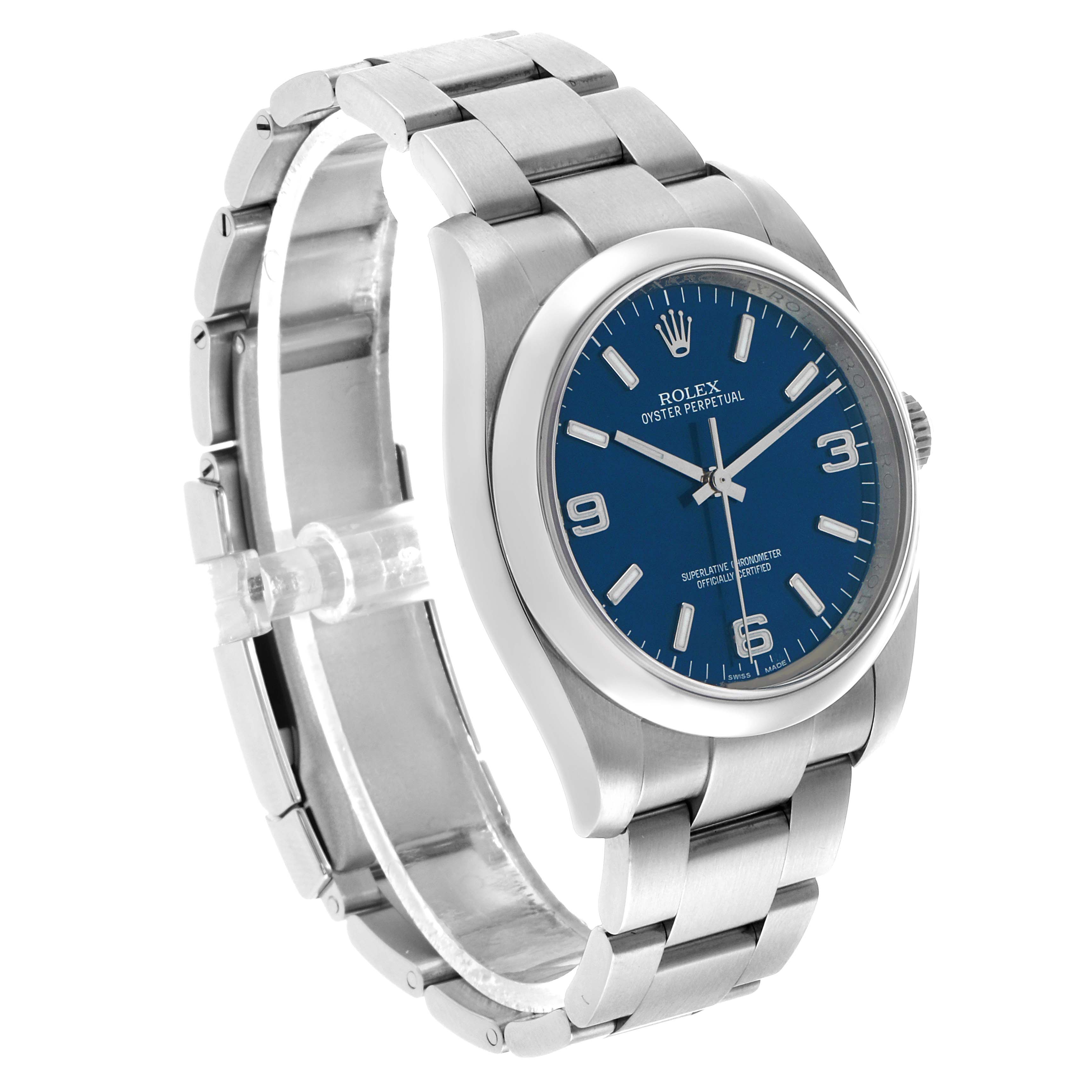 The Rolex Oyster Perpetual 116000 Men's Stainless Steel Blue Dial watch is shown from a three-quarter angle, displaying the bracelet, case, and blue dial.