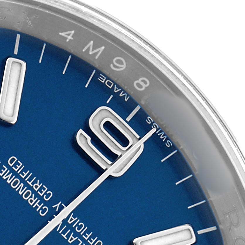 The image shows a close-up of the Rolex Oyster Perpetual 116000 Men's Stainless Steel Blue Dial watch face, focusing on the dial, hour markers, and part of the bezel.