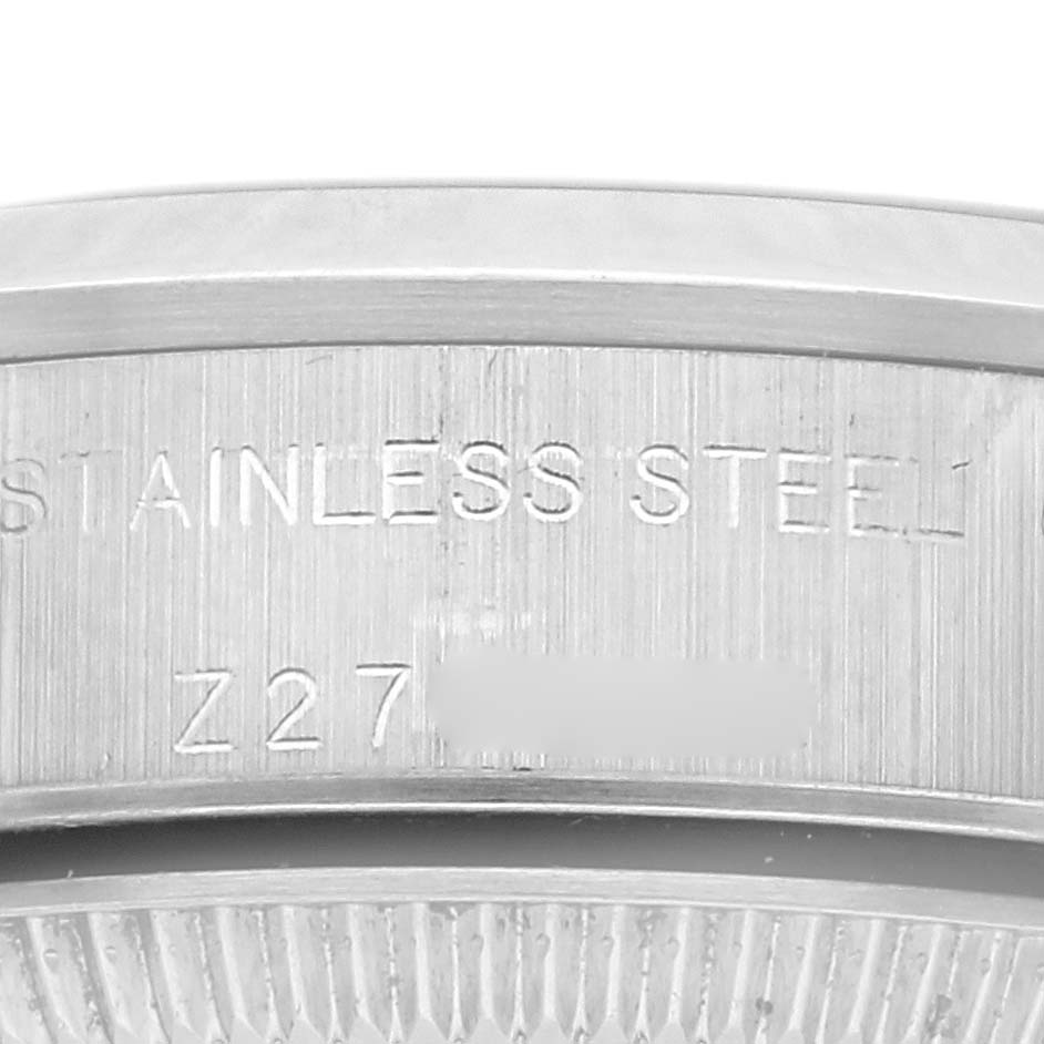 The image shows a close-up of the side of a Rolex Oyster Perpetual 76080 Women's Stainless Steel Pink Dial 76080 Women's Stainless Steel Pink Dial watch, highlighting the "STAINLESS STEEL" engraving.