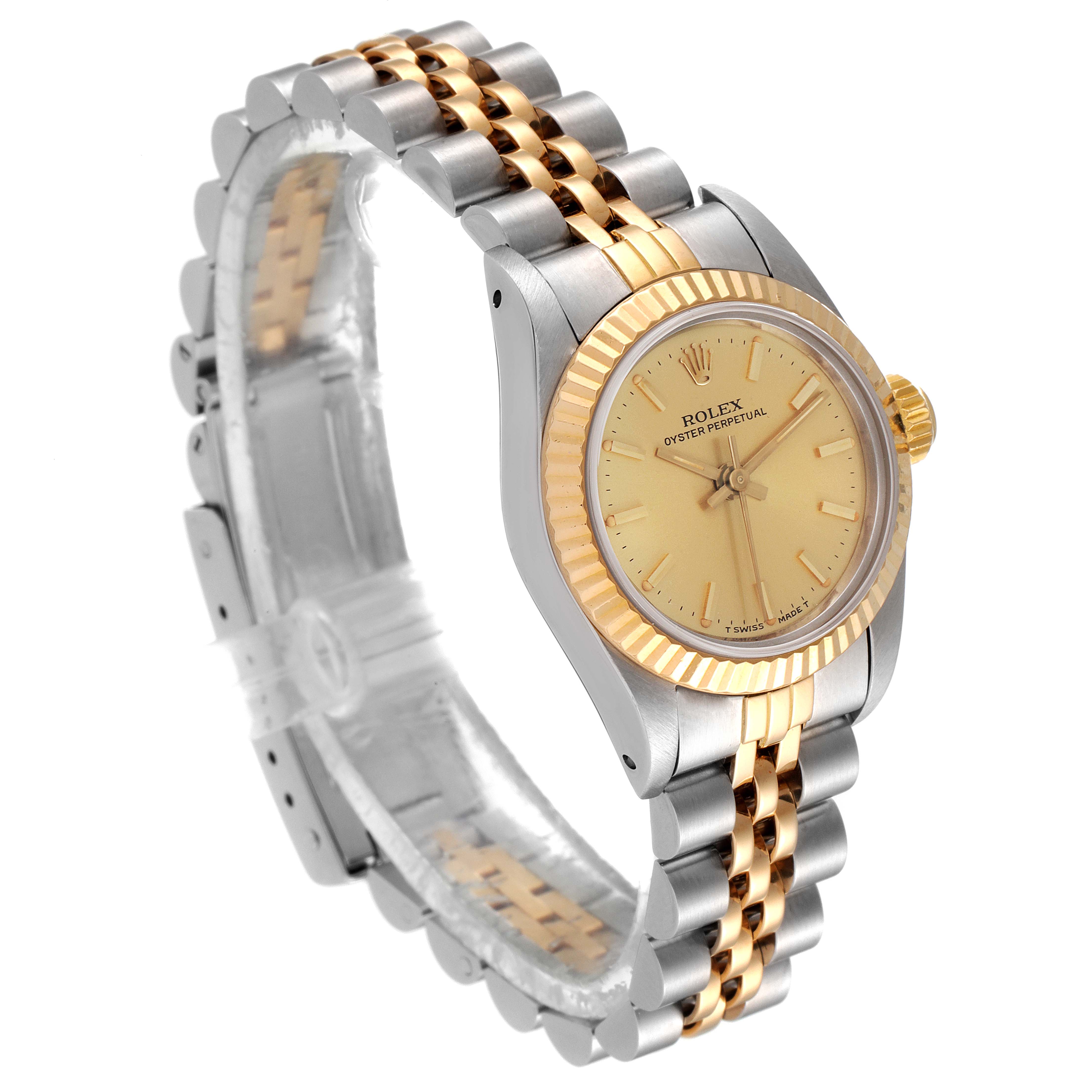 This is a side angle shot of a Rolex Oyster Perpetual 67193 Women's Steel and Gold (two tone) Champagne Dial 67193 Women's Steel and Gold (two tone) Champagne Dial watch, showing the dial, bezel, and two-tone bracelet.
