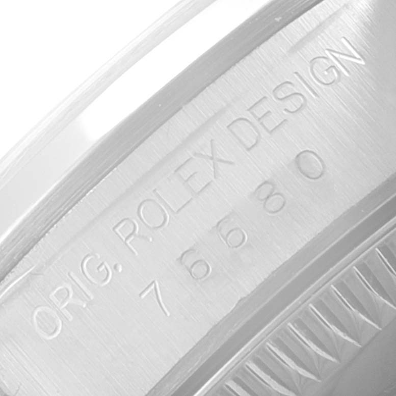 This image shows a close-up of the engraving on the casing of a Rolex Oyster Perpetual 76080 Women
s Stainless Steel Pink Dial 76080 Women
s Stainless Steel Pink Dial watch, displaying the words "ORIG. ROLEX DESIGN" and the model number.